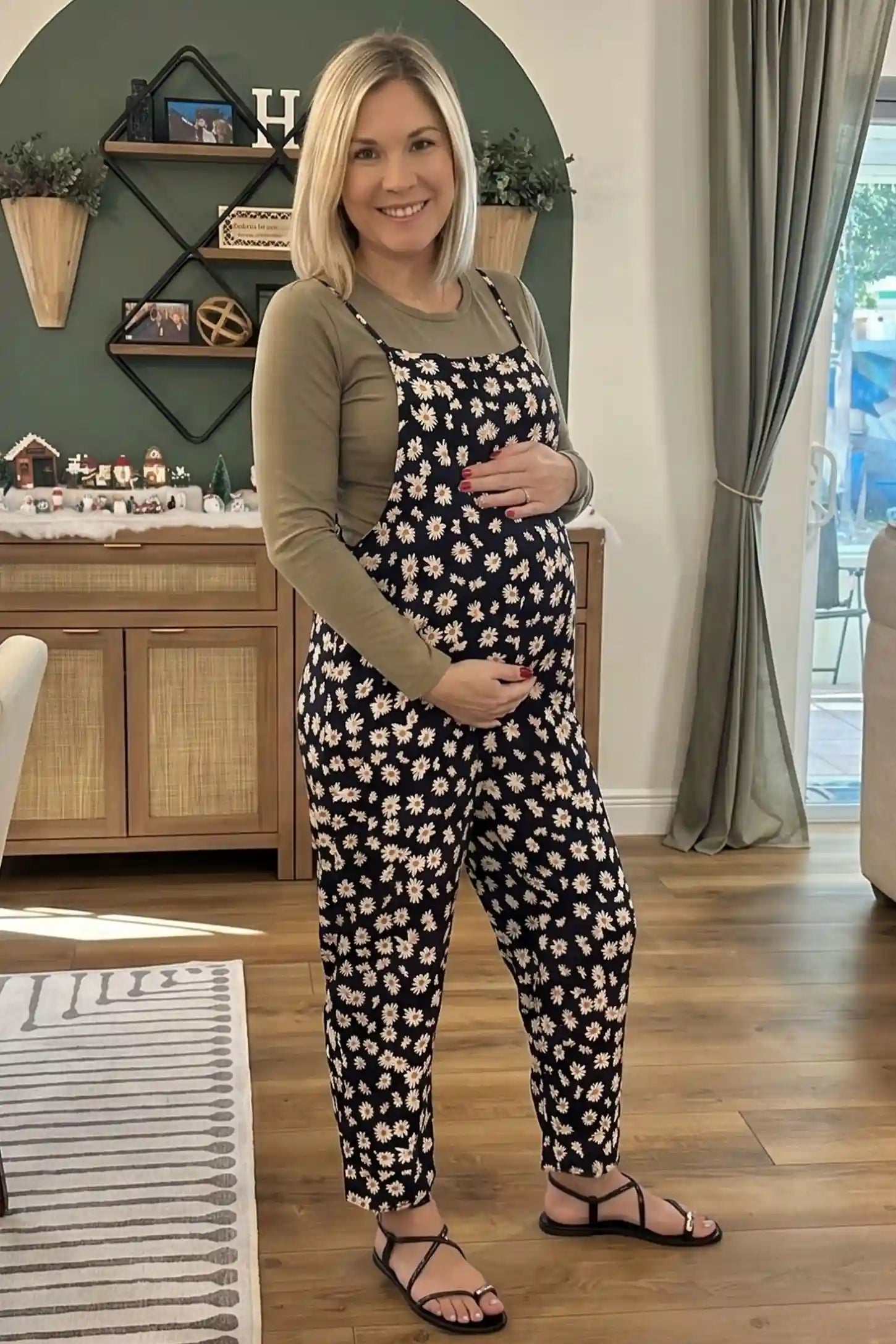 Floral Wide-Leg Pocket Maternity Jumpsuit Floral Wide-Leg Pocket Jumpsuit in Black featuring an all-over daisy print on a pregnant model, UGC indoor view
