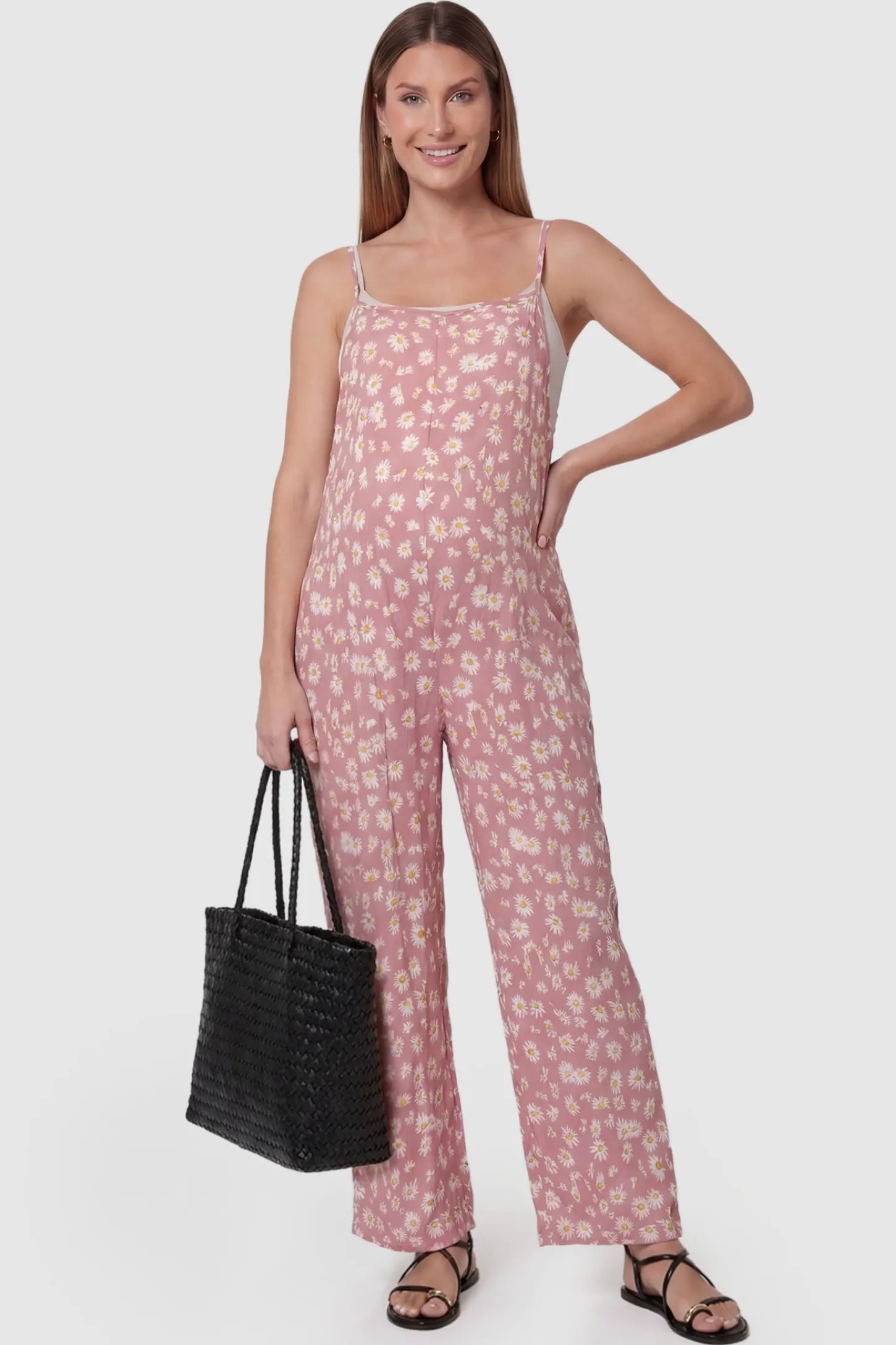 Floral Wide-Leg Pocket Jumpsuit in Pink featuring an all-over daisy print on a pregnant model, front view.