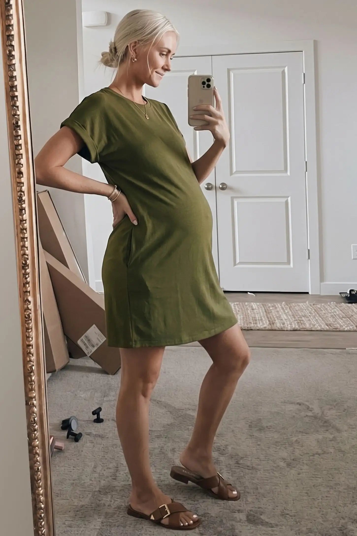 Flowy Pocket Tunic Maternity T-Shirt Dress Flowy Pocket Tunic Maternity T-Shirt Dress in Army Green featuring functional side pockets on a side-view pregnant model.