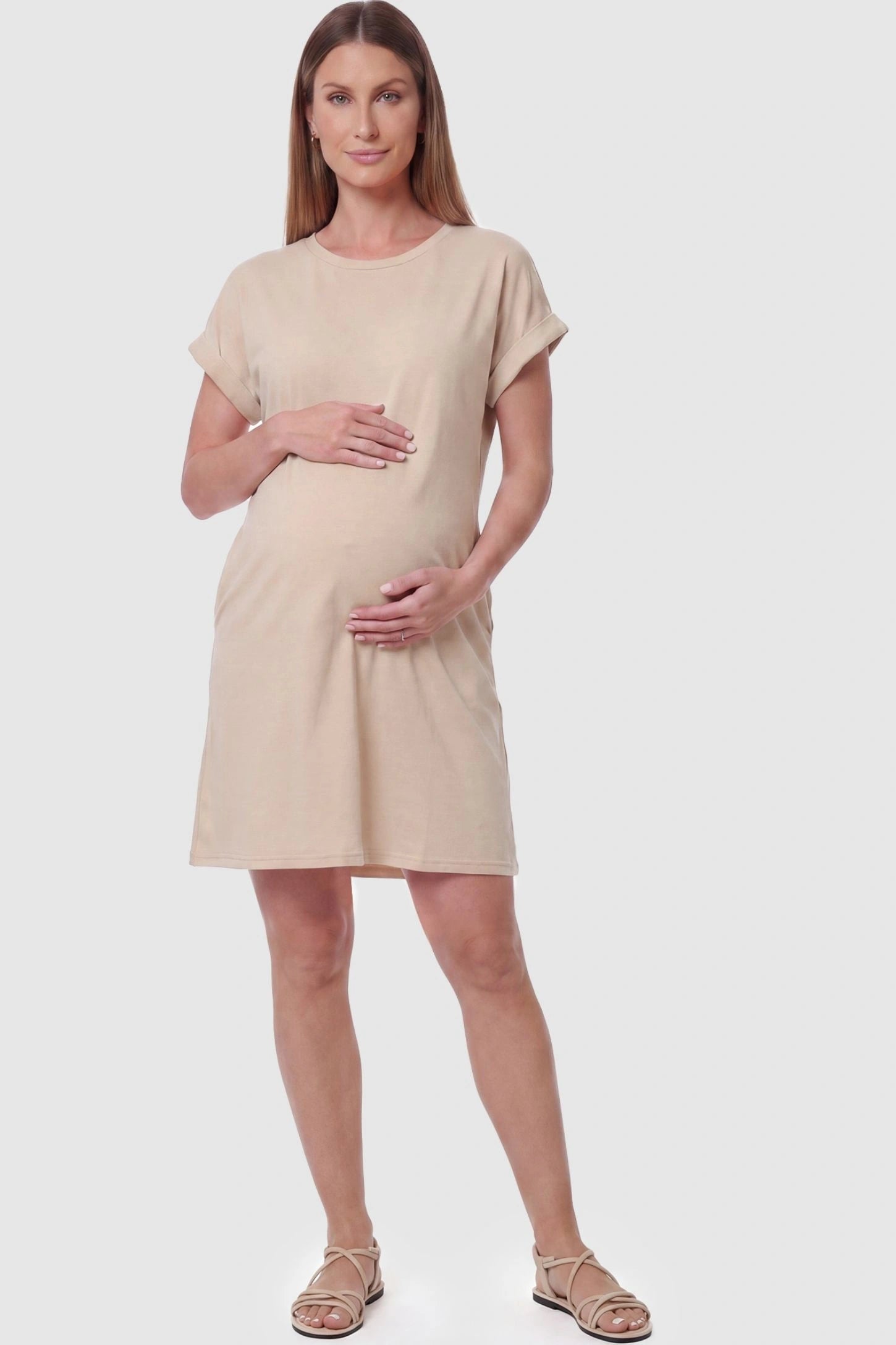 Flowy Pocket Tunic Maternity T-Shirt Dress Flowy Pocket Tunic Maternity T-Shirt Dress in Beige featuring a relaxed fit on a front-view pregnant model.