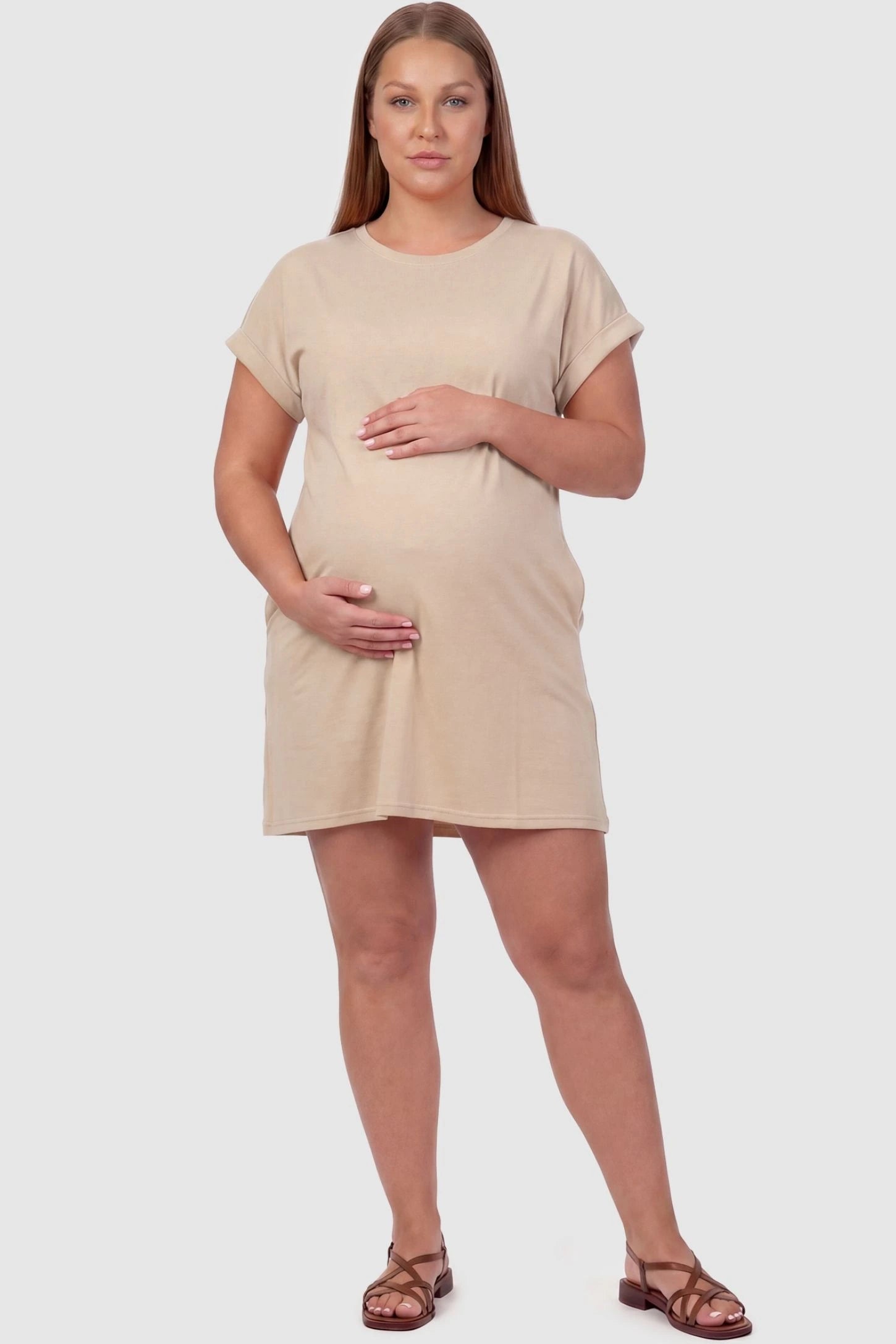 Flowy Pocket Tunic Maternity T-Shirt Dress Flowy Pocket Tunic Maternity T-Shirt Dress in Beige featuring cuffed short sleeves on a front-view plus size model.