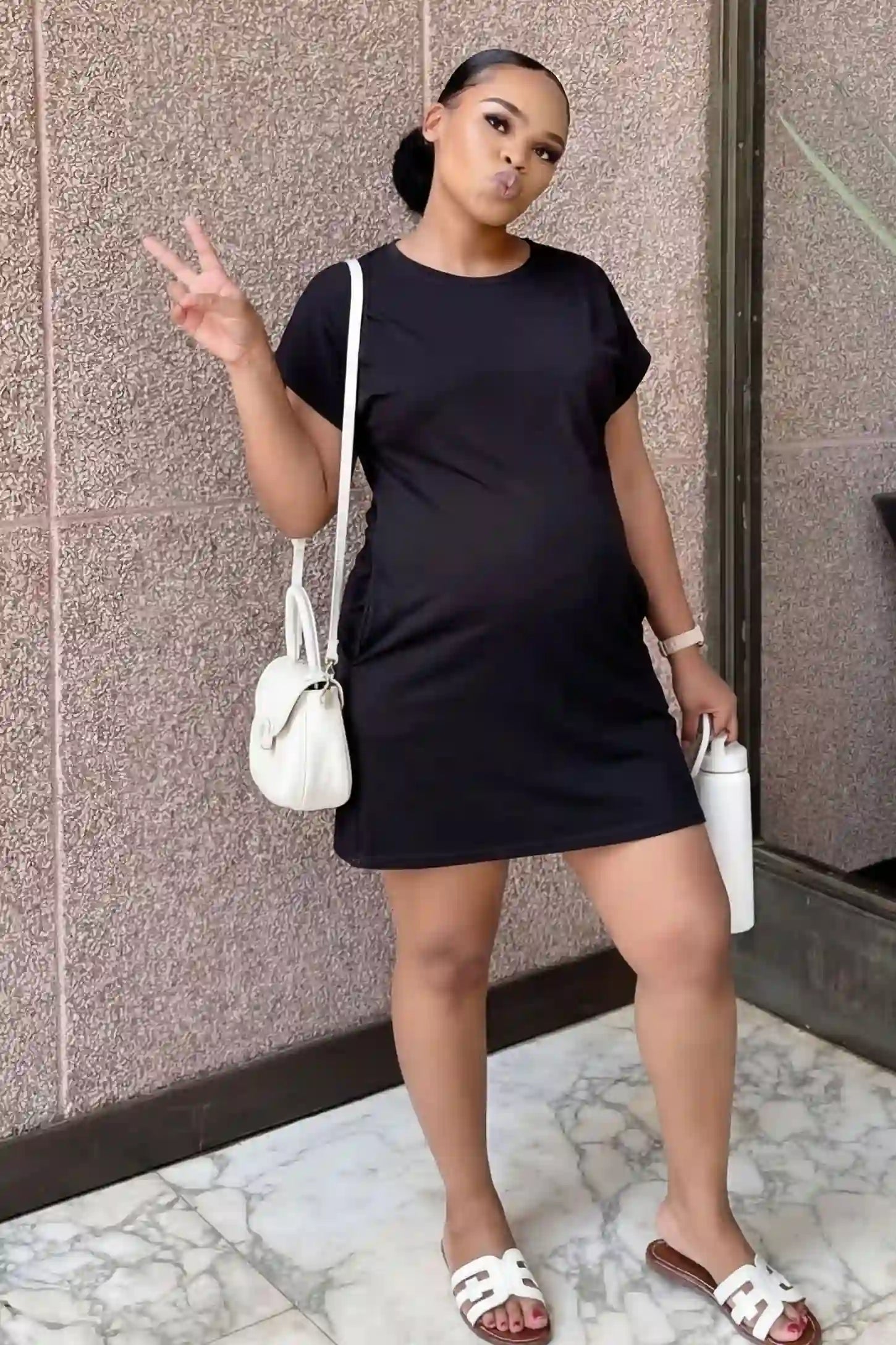 Flowy Pocket Tunic Maternity T-Shirt Dress Flowy Pocket Tunic Maternity T-Shirt Dress in Black featuring a relaxed fit on a front-view pregnant model.