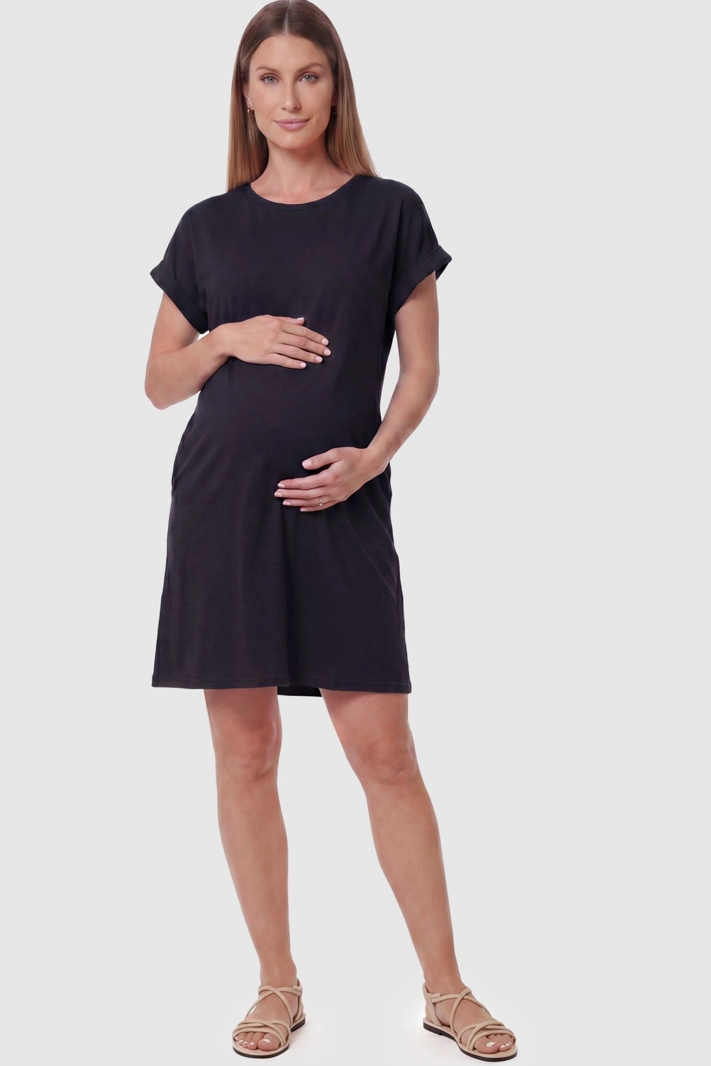 Flowy Pocket Tunic Maternity T-Shirt Dress Flowy Pocket Tunic Maternity T-Shirt Dress in Black featuring a relaxed fit on a front-view pregnant model.