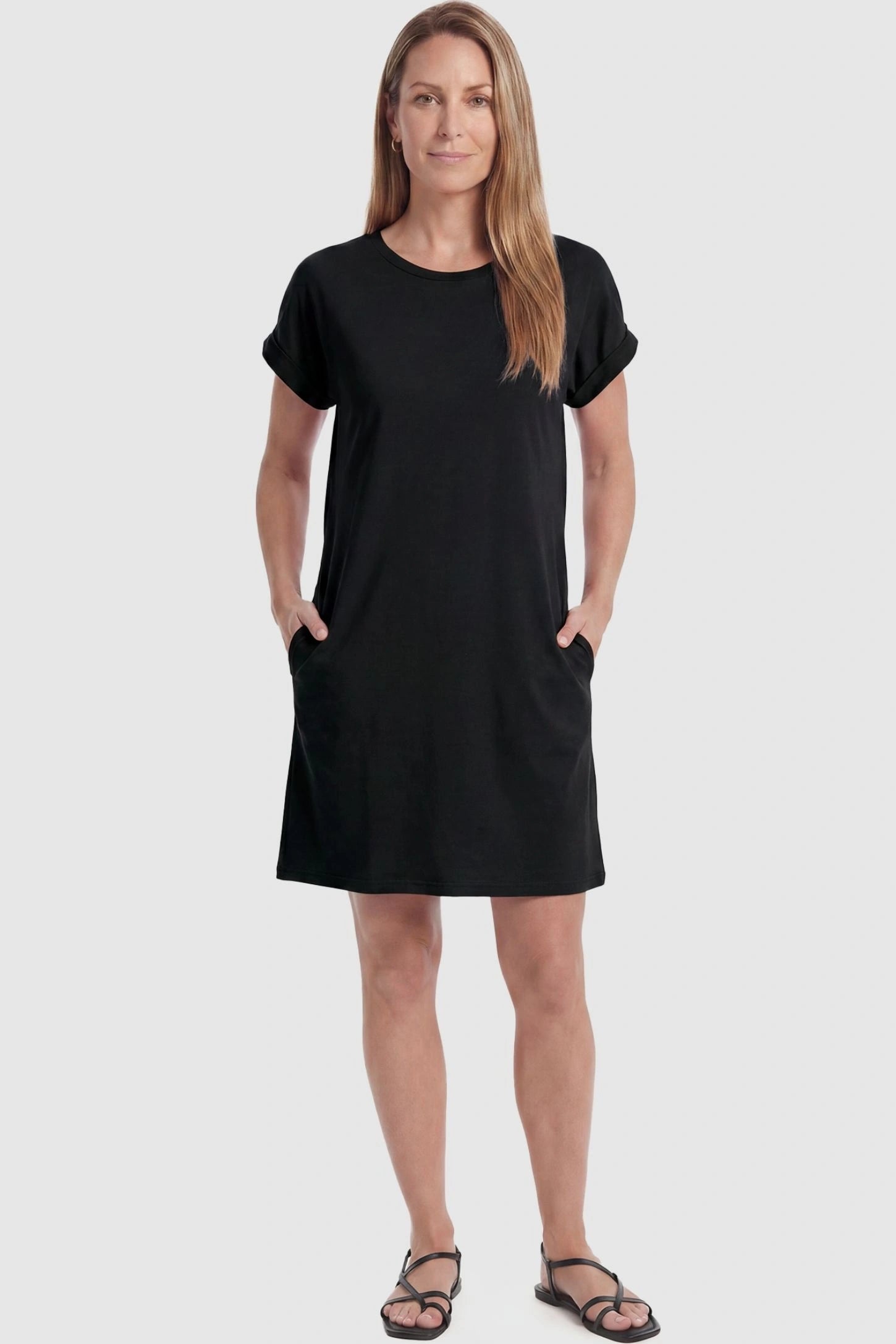 Flowy Pocket Tunic Maternity T-Shirt Dress Flowy Pocket Tunic Maternity T-Shirt Dress in Black featuring cuffed short sleeves on a front-view postpartum model.