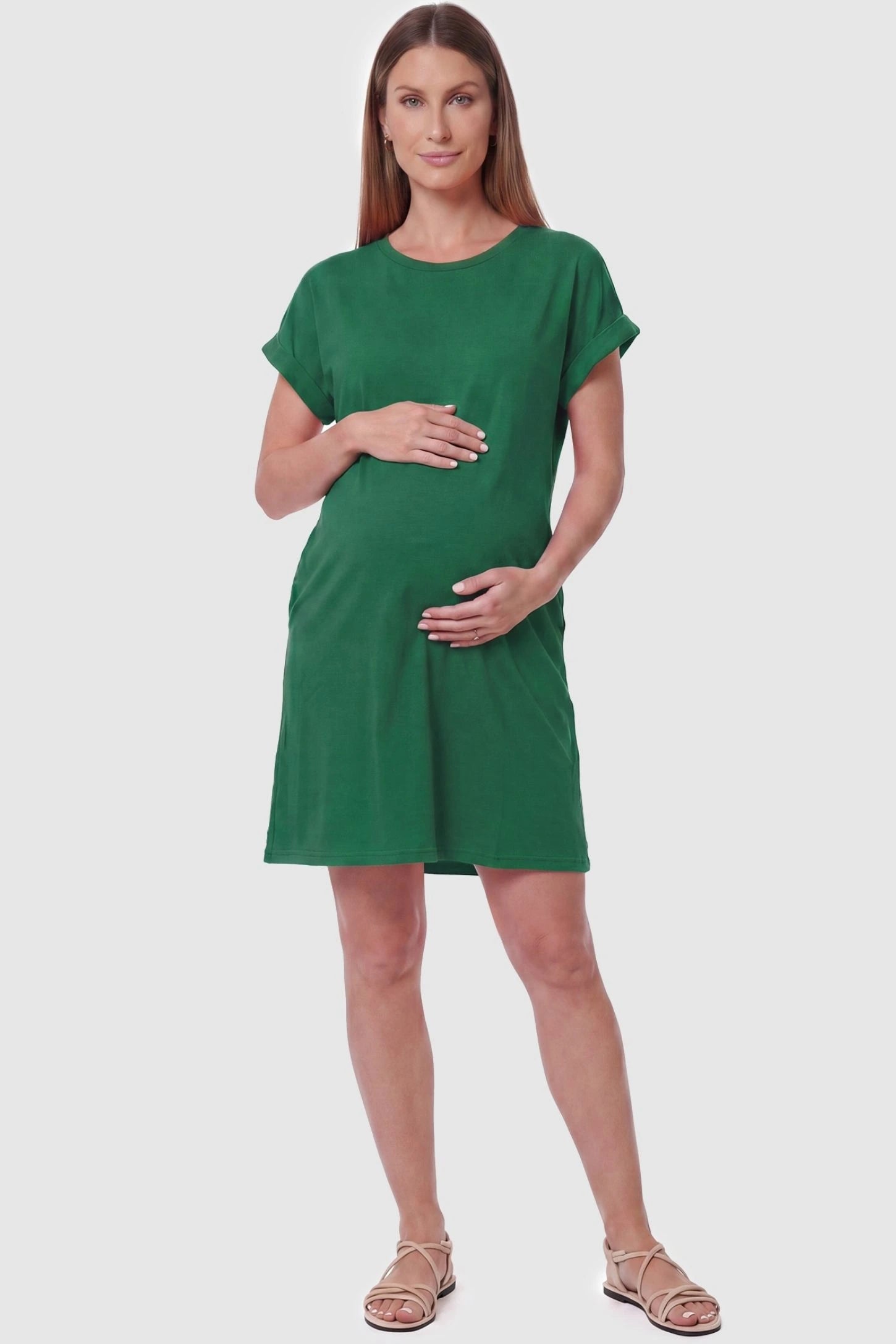 Flowy Pocket Tunic Maternity T-Shirt Dress Flowy Pocket Tunic Maternity T-Shirt Dress in Green featuring a relaxed fit on a front-view pregnant model.