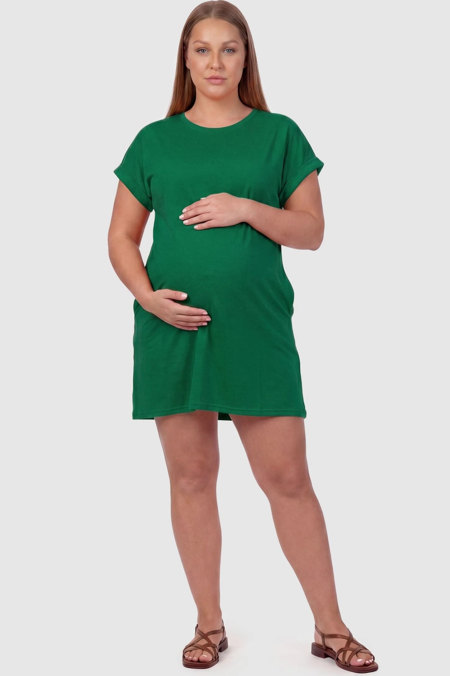 Flowy Pocket Tunic Maternity T-Shirt Dress Flowy Pocket Tunic Maternity T-Shirt Dress in Green featuring stretchy cotton-blend fabric on a front-view plus size pregnant model.