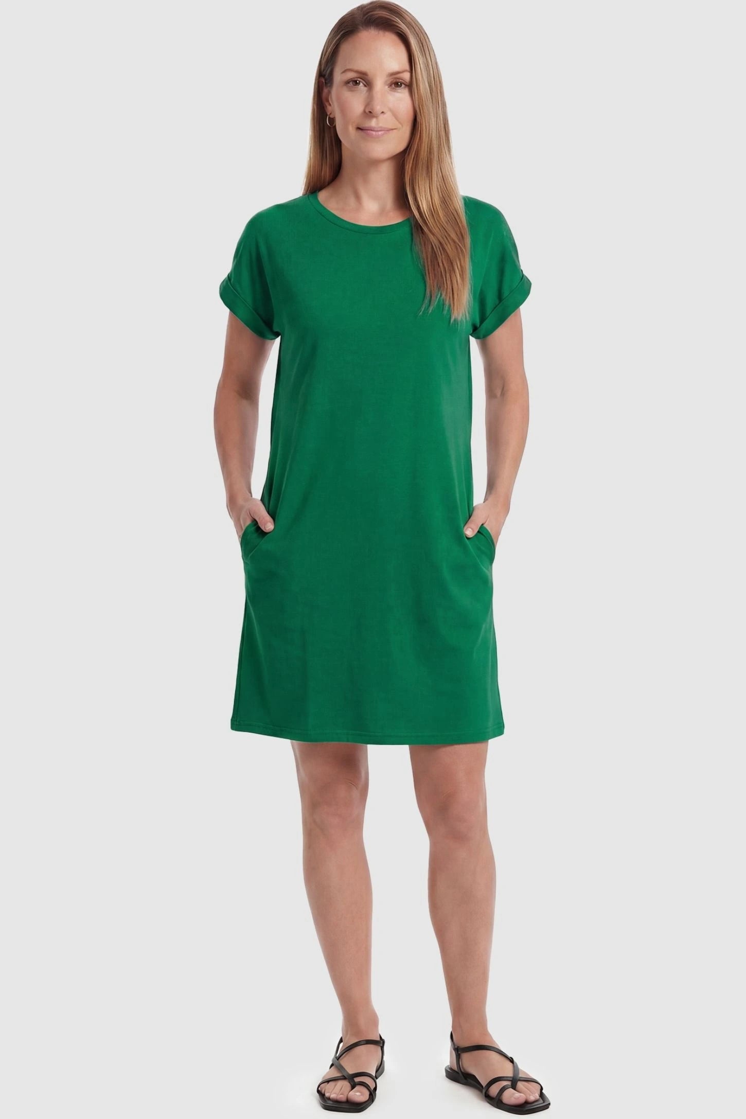Flowy Pocket Tunic Maternity T-Shirt Dress Flowy Pocket Tunic Maternity T-Shirt Dress in Green featuring cuffed short sleeves on a front-view postpartum model.