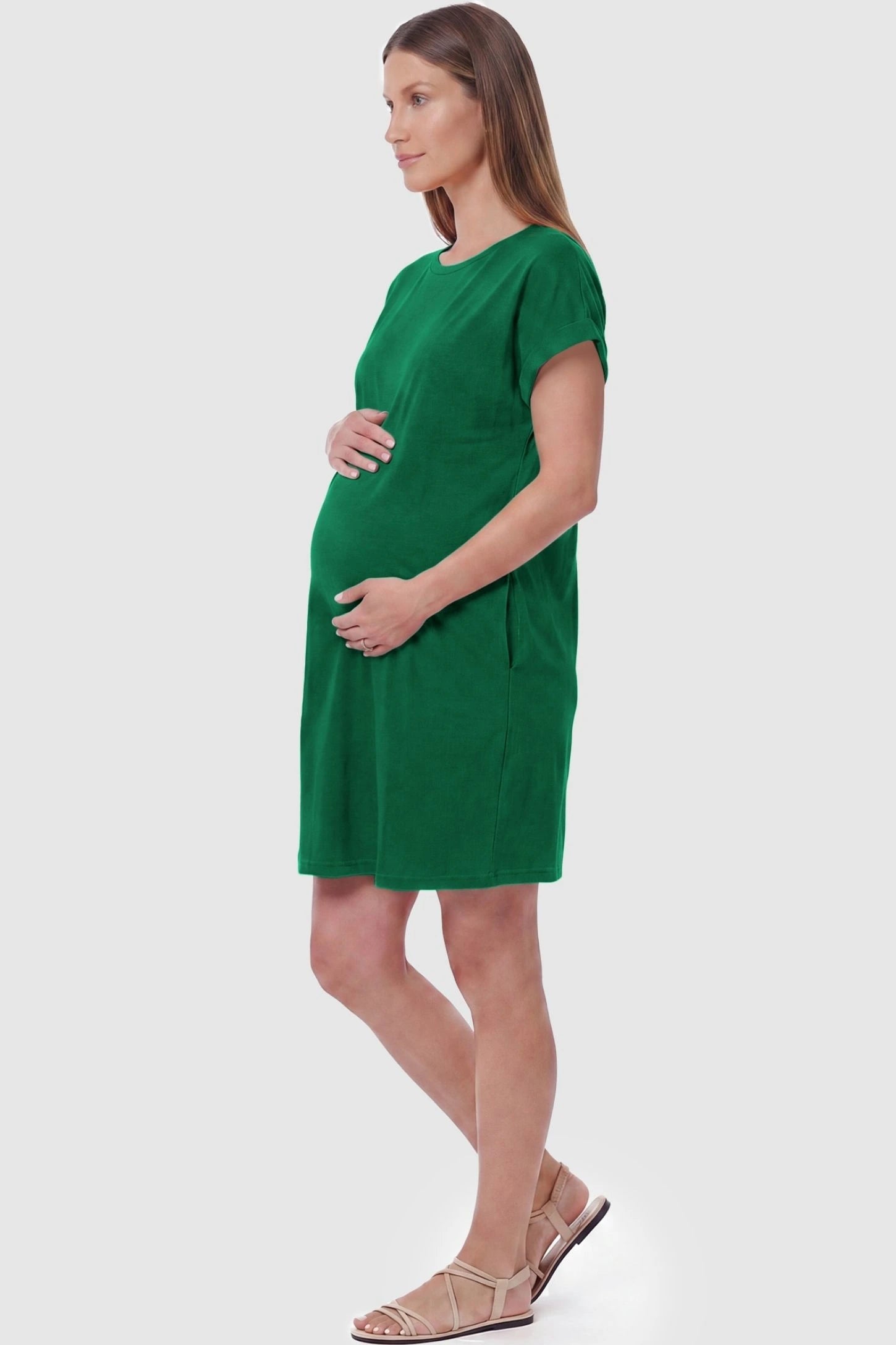 Flowy Pocket Tunic Maternity T-Shirt Dress Flowy Pocket Tunic Maternity T-Shirt Dress in Green featuring functional side pockets on a side-view pregnant model.