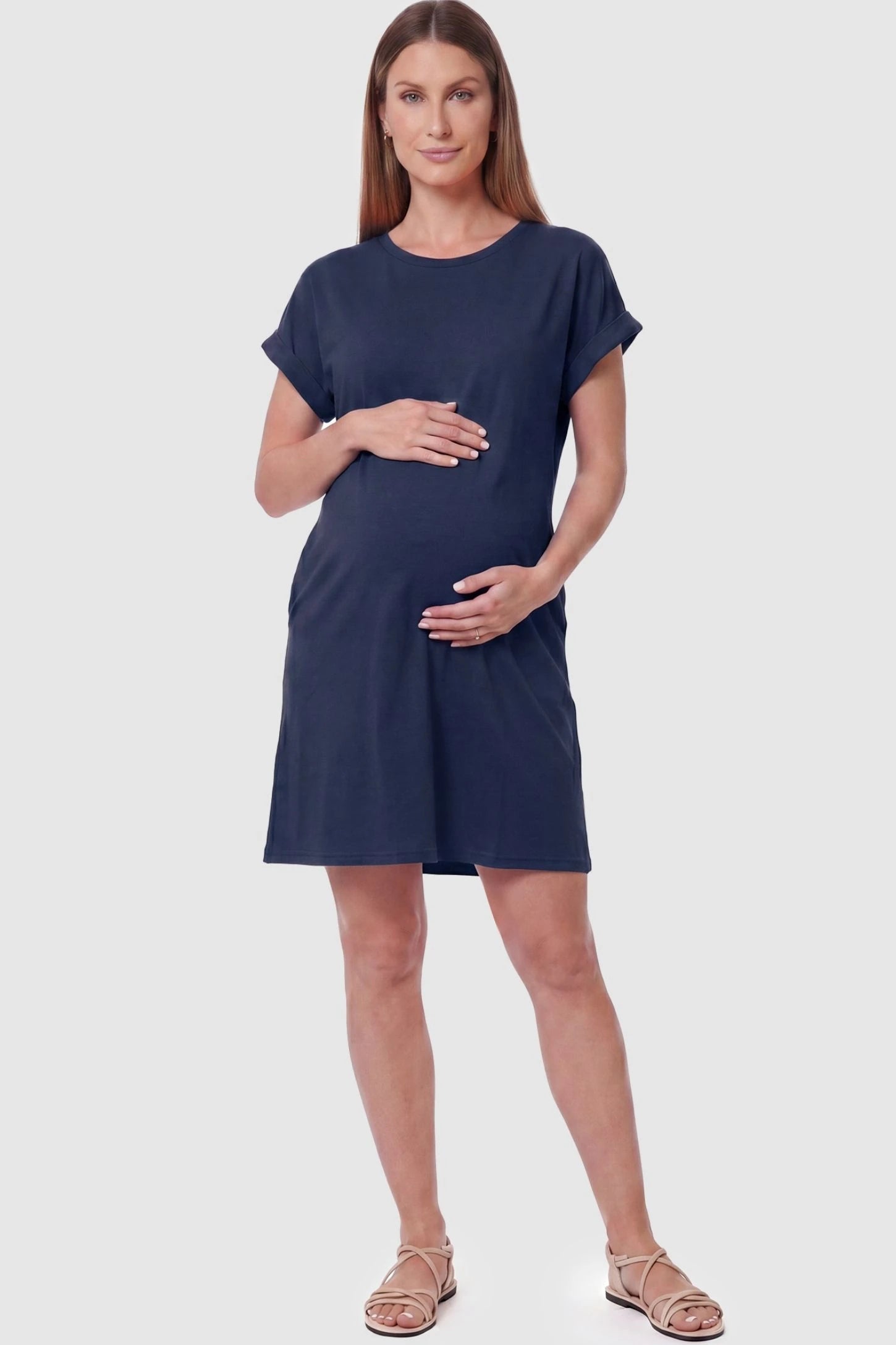 Flowy Pocket Tunic Maternity T-Shirt Dress Flowy Pocket Tunic Maternity T-Shirt Dress in Navy Blue featuring a relaxed fit on a front-view pregnant model.