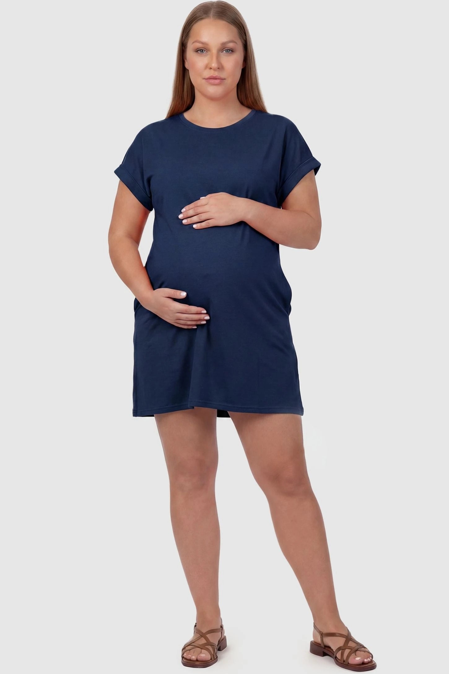 Flowy Pocket Tunic Maternity T-Shirt Dress Flowy Pocket Tunic Maternity T-Shirt Dress in Navy Blue featuring cuffed short sleeves on a front-view plus size model.