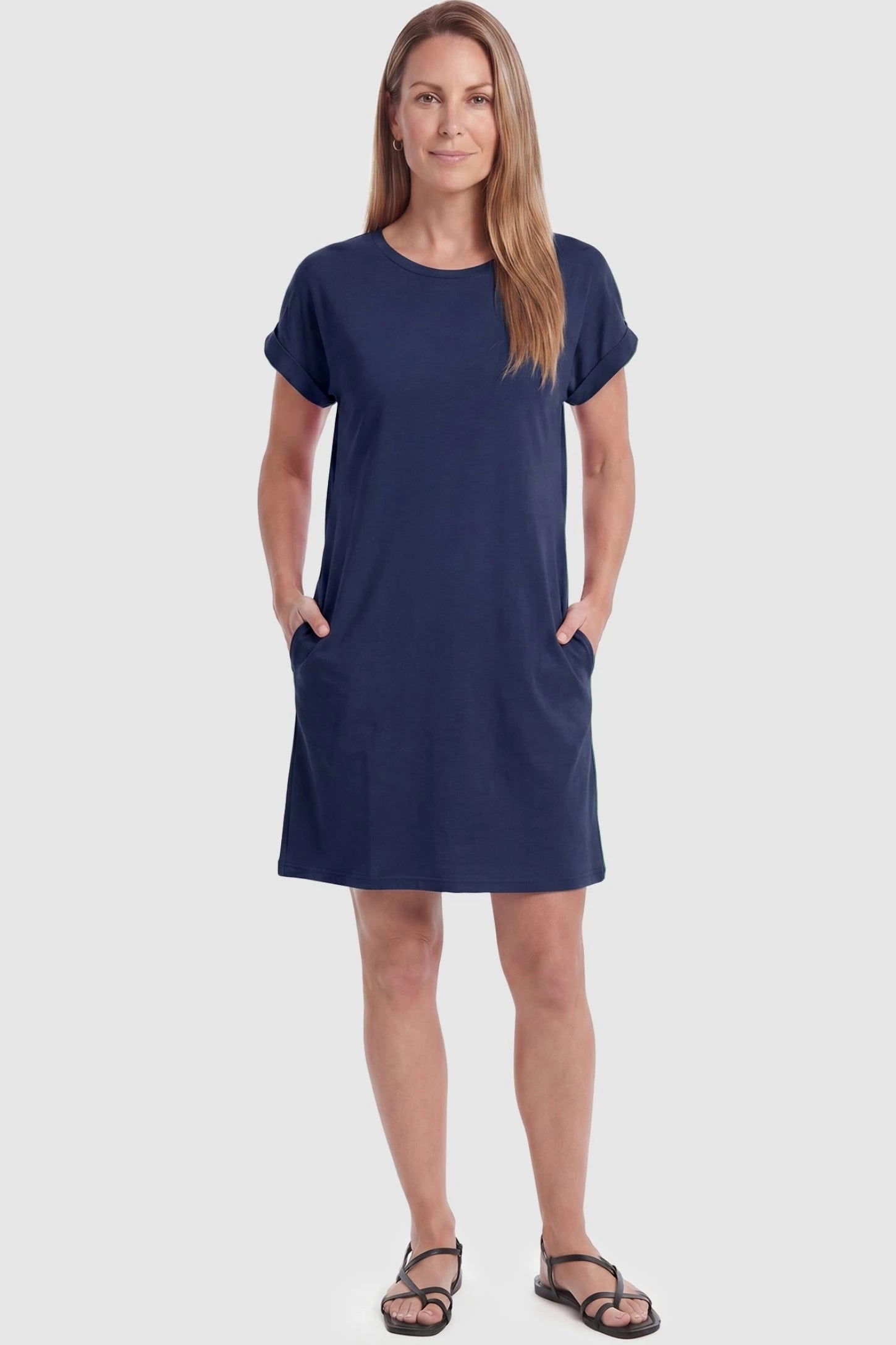 Flowy Pocket Tunic Maternity T-Shirt Dress Flowy Pocket Tunic Maternity T-Shirt Dress in Navy Blue featuring cuffed short sleeves on a front-view postpartum model.