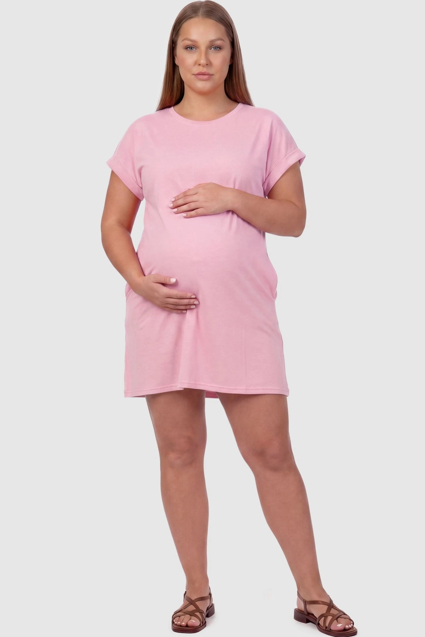 Flowy Pocket Tunic Maternity T-Shirt Dress Flowy Pocket Tunic Maternity T-Shirt Dress in Pink featuring cuffed short sleeves on a front-view plus size model.