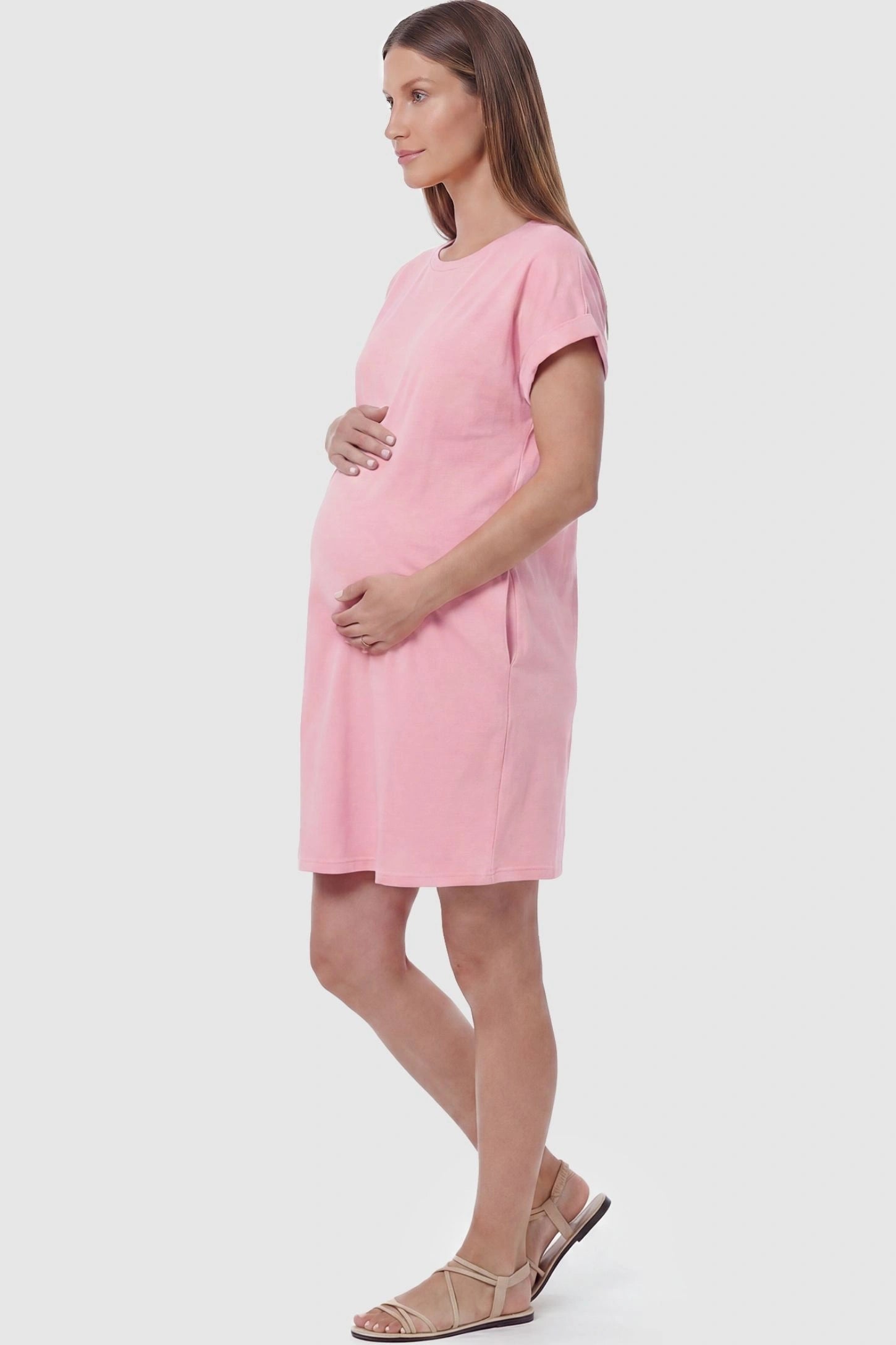 Flowy Pocket Tunic Maternity T-Shirt Dress Flowy Pocket Tunic Maternity T-Shirt Dress in Pink featuring functional side pockets on a side-view pregnant model.