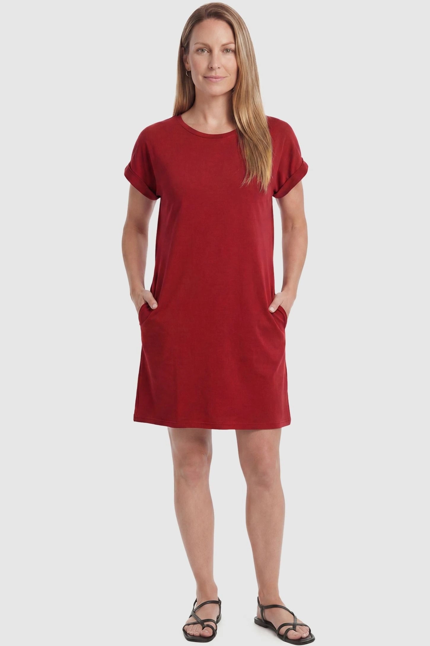Flowy Pocket Tunic Maternity T-Shirt Dress Flowy Pocket Tunic Maternity T-Shirt Dress in Red featuring cuffed short sleeves on a front-view postpartum model.