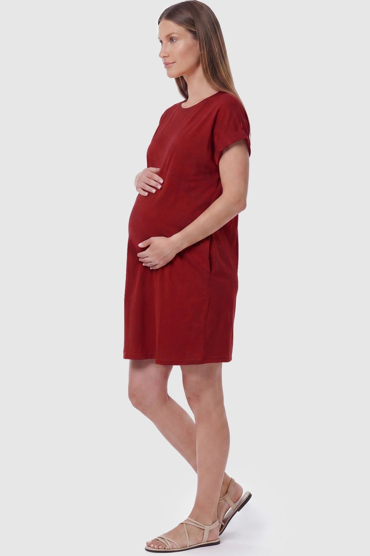 Flowy Pocket Tunic Maternity T-Shirt Dress Flowy Pocket Tunic Maternity T-Shirt Dress in Red featuring functional side pockets on a side-view pregnant model.