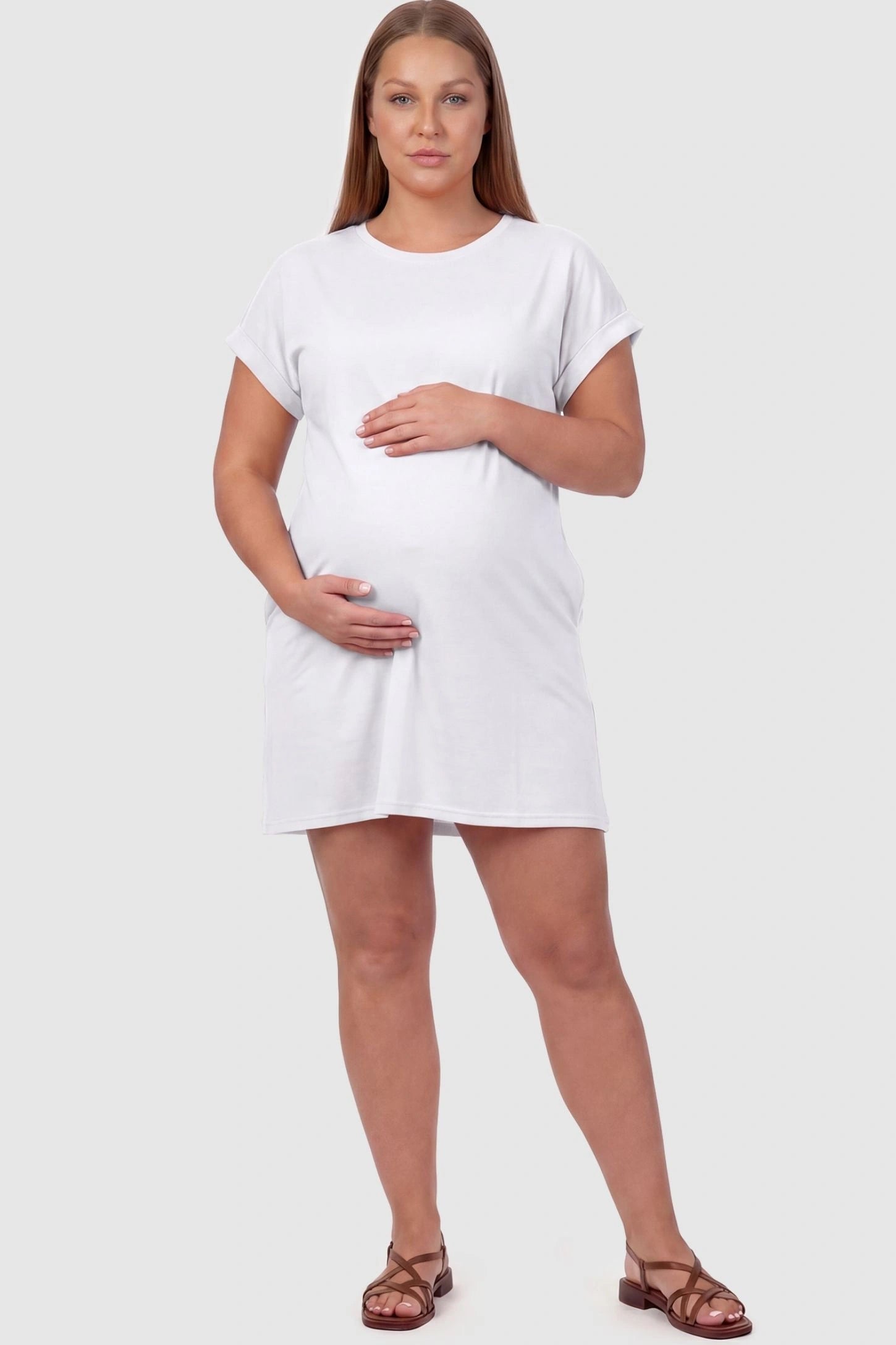 Flowy Pocket Tunic Maternity T-Shirt Dress Flowy Pocket Tunic Maternity T-Shirt Dress in White featuring cuffed short sleeves on a front-view plus size model.