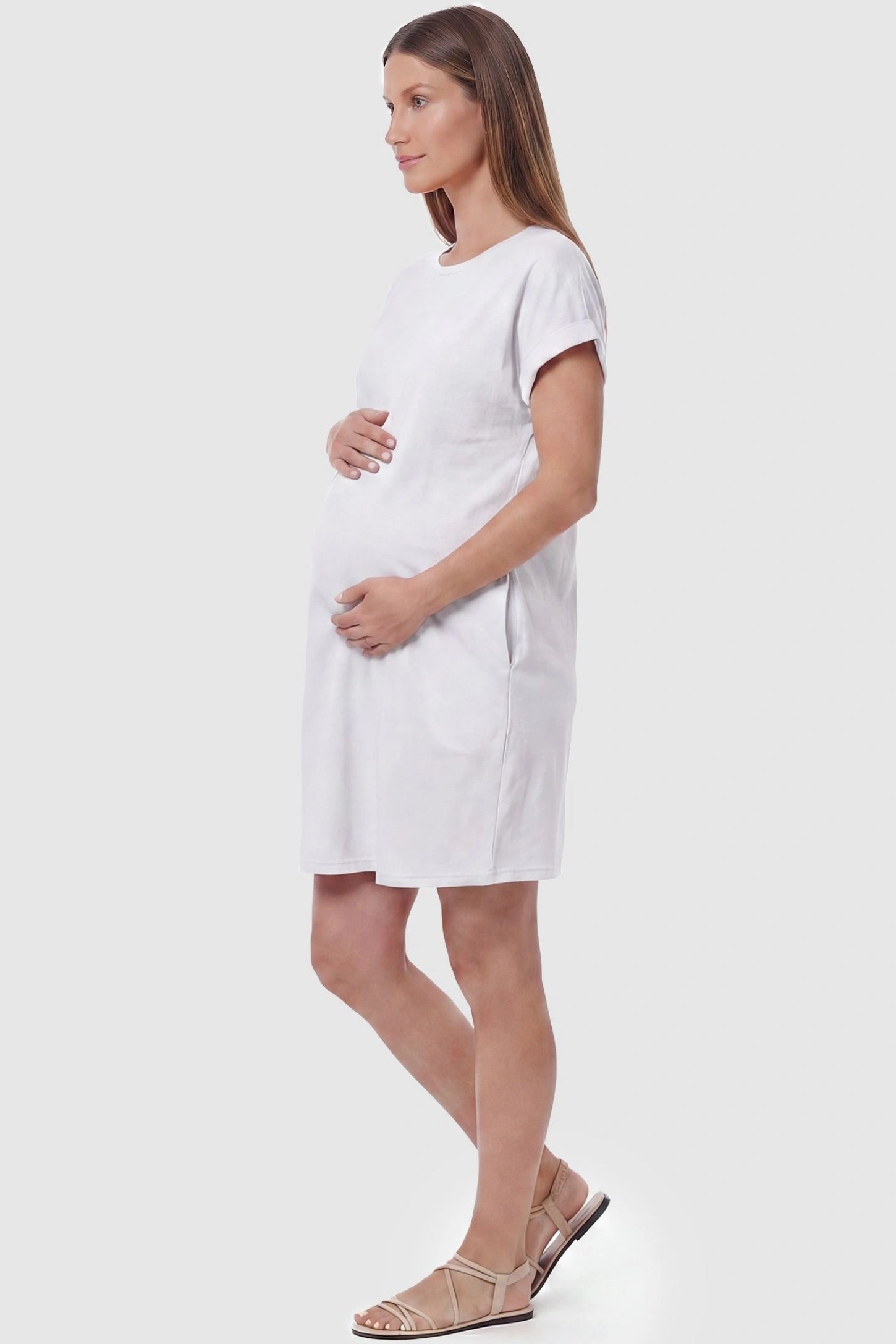 Flowy Pocket Tunic Maternity T-Shirt Dress Flowy Pocket Tunic Maternity T-Shirt Dress in White featuring functional side pockets on a side-view pregnant model.