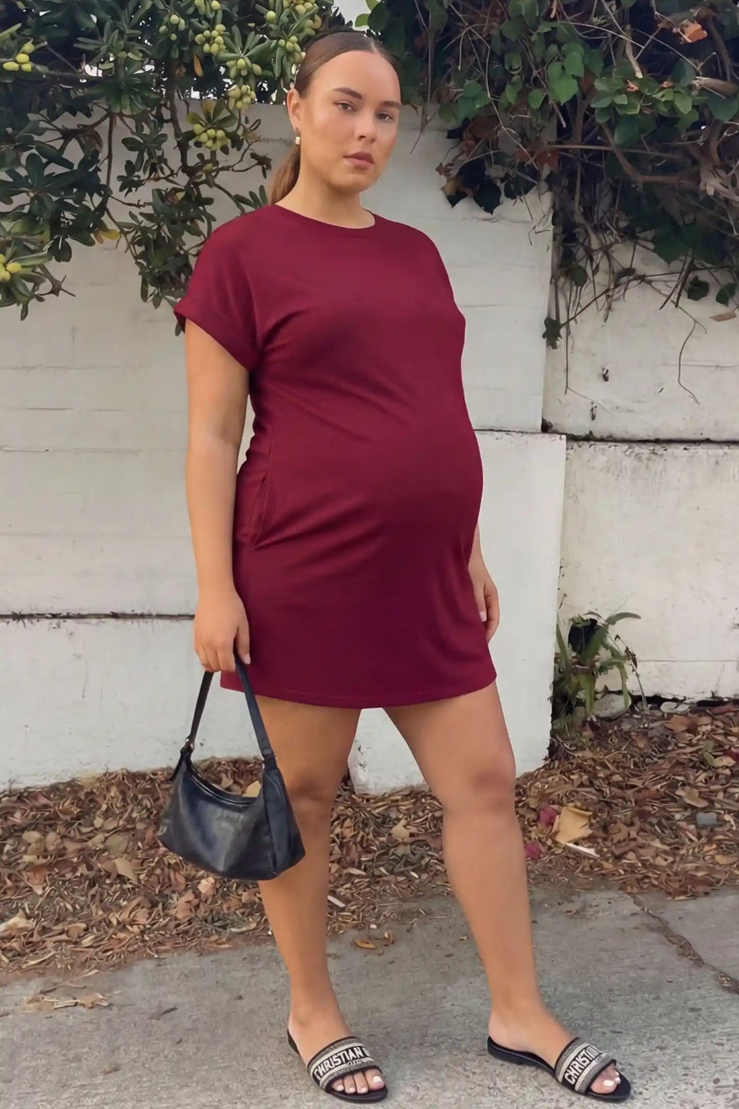 Flowy Pocket Tunic Maternity T-Shirt Dress Flowy Pocket Tunic Maternity T-Shirt Dress in Wine Red featuring a relaxed fit on a front-view pregnant model.