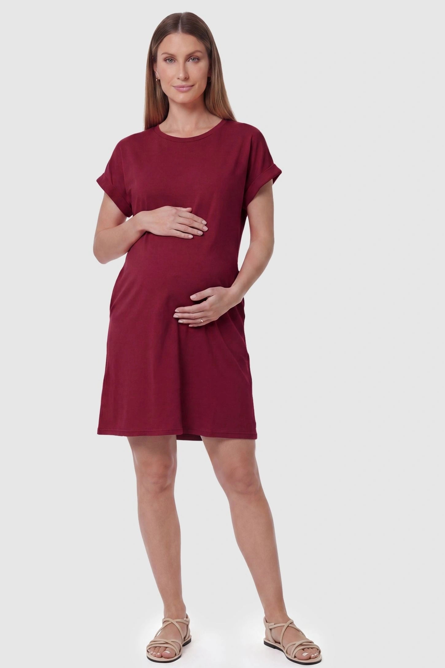 Flowy Pocket Tunic Maternity T-Shirt Dress Flowy Pocket Tunic Maternity T-Shirt Dress in Wine Red featuring a relaxed fit on a front-view pregnant model.