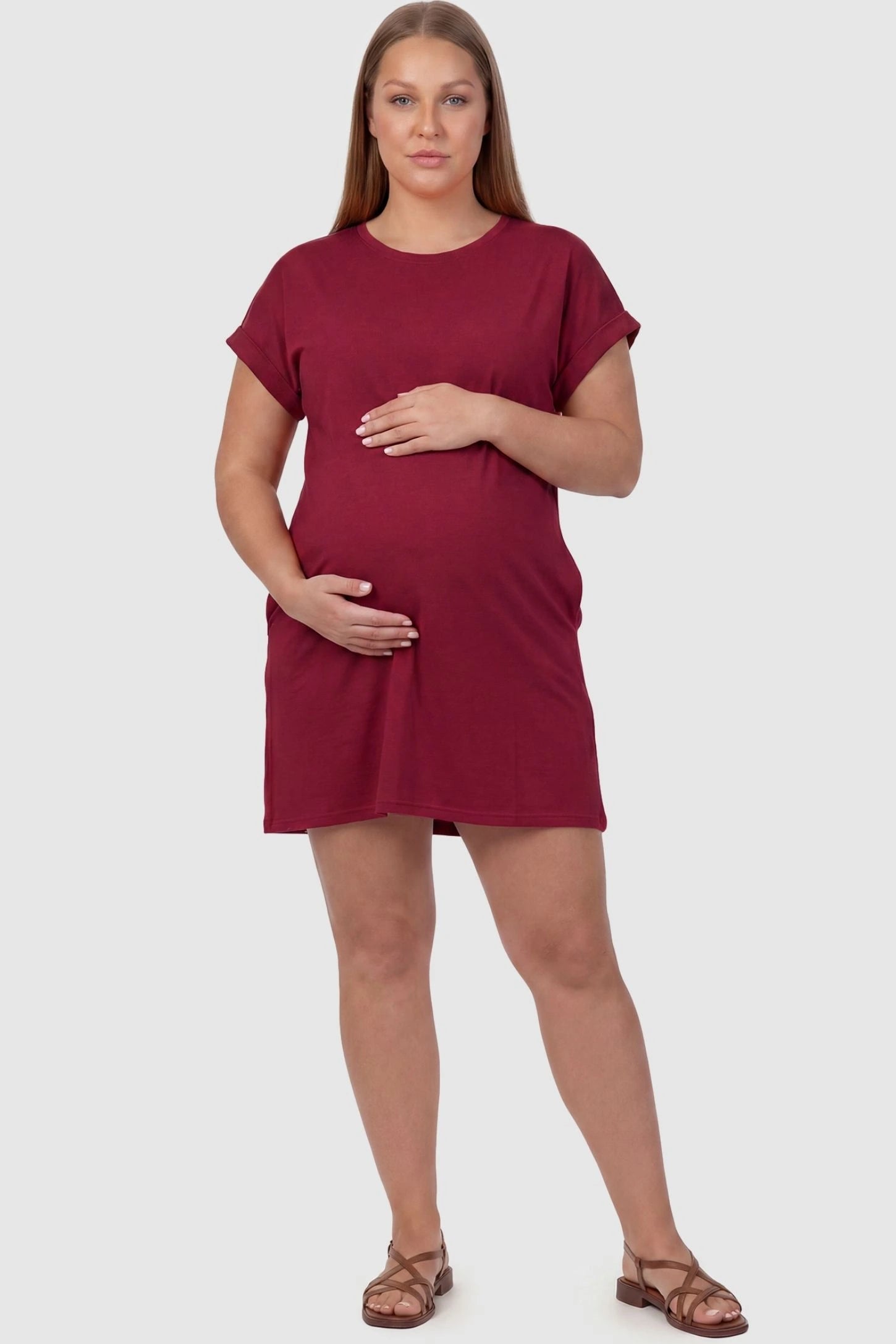 Flowy Pocket Tunic Maternity T-Shirt Dress Flowy Pocket Tunic Maternity T-Shirt Dress in Wine Red featuring cuffed short sleeves on a front-view plus size model.
