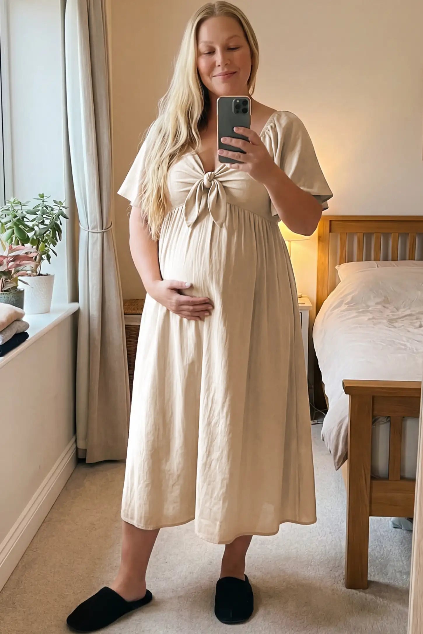 Front Tie Flutter Sleeve Maternity Midi Dress Front Tie Flutter Sleeve Maternity Midi Dress in Apricot featuring a knotted V-neckline and flowy skirt on a pregnant woman.