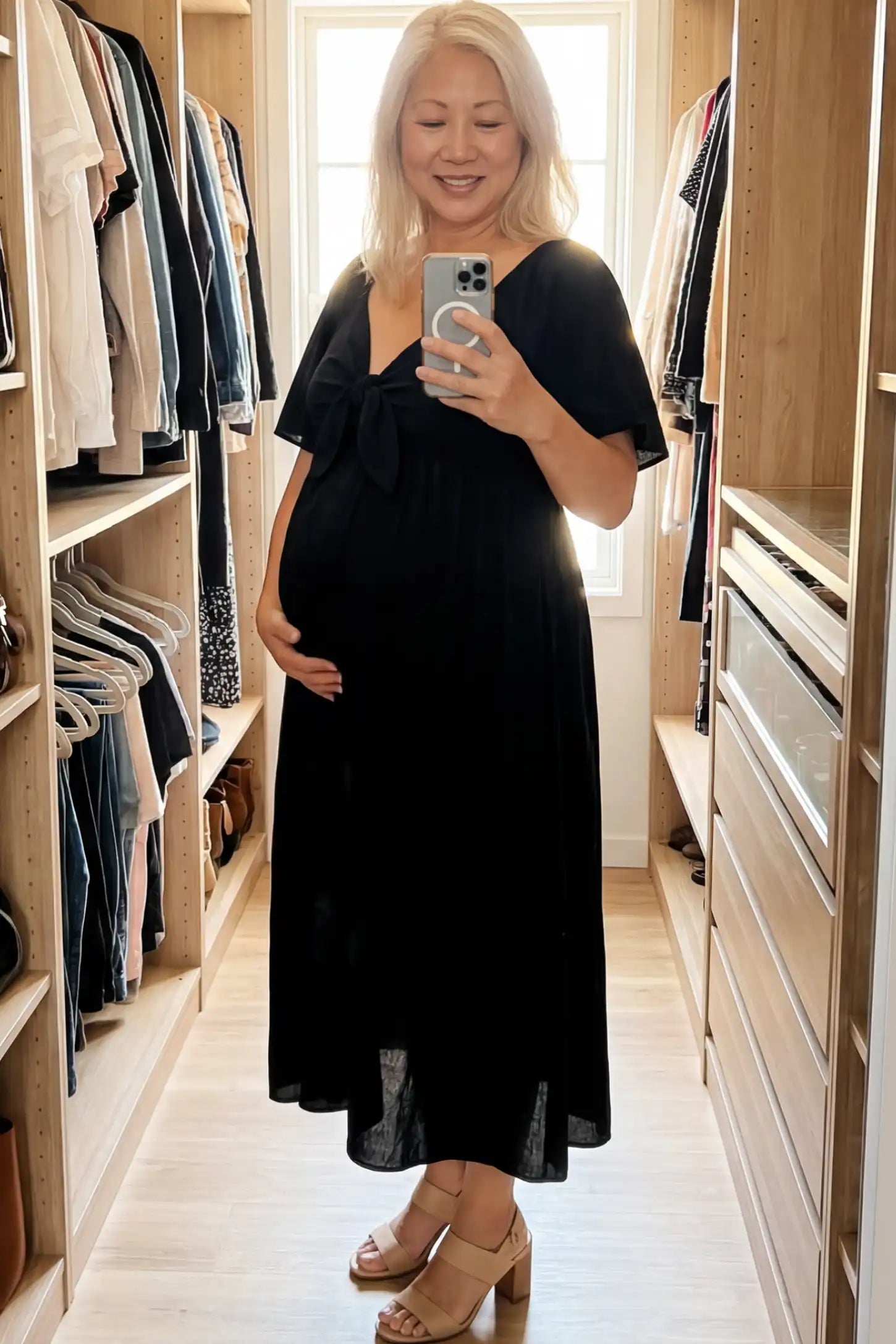 Front Tie Flutter Sleeve Maternity Midi Dress Front Tie Flutter Sleeve Maternity Midi Dress in Black featuring a knotted V-neckline and flowy skirt on a pregnant woman.