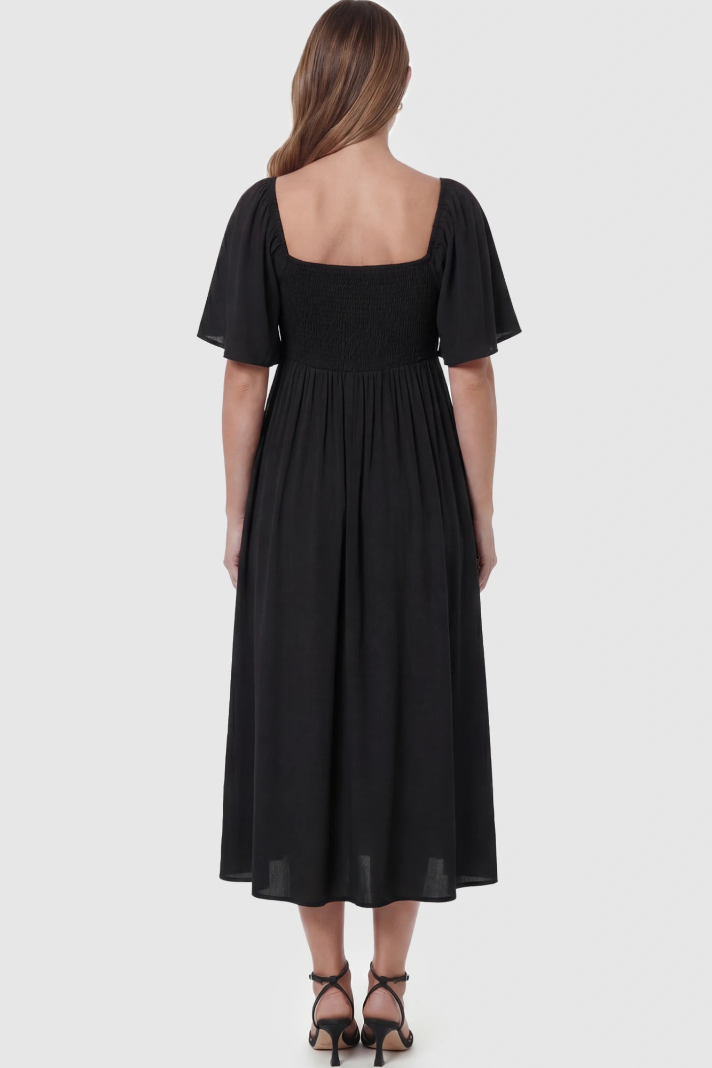 Front Tie Flutter Sleeve Maternity Midi Dress Front Tie Flutter Sleeve Maternity Midi Dress in Black featuring a knotted V-neckline and flowy skirt on a pregnant model showing back.