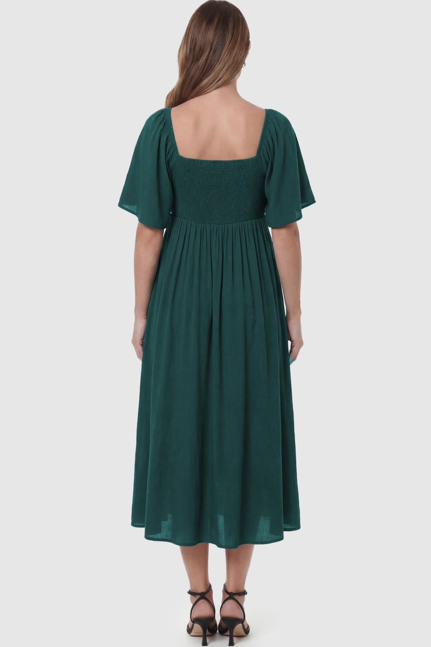 Front Tie Flutter Sleeve Maternity Midi Dress Front Tie Flutter Sleeve Maternity Midi Dress in Emerald Green featuring a knotted V-neckline and flowy skirt on a pregnant model showing back.