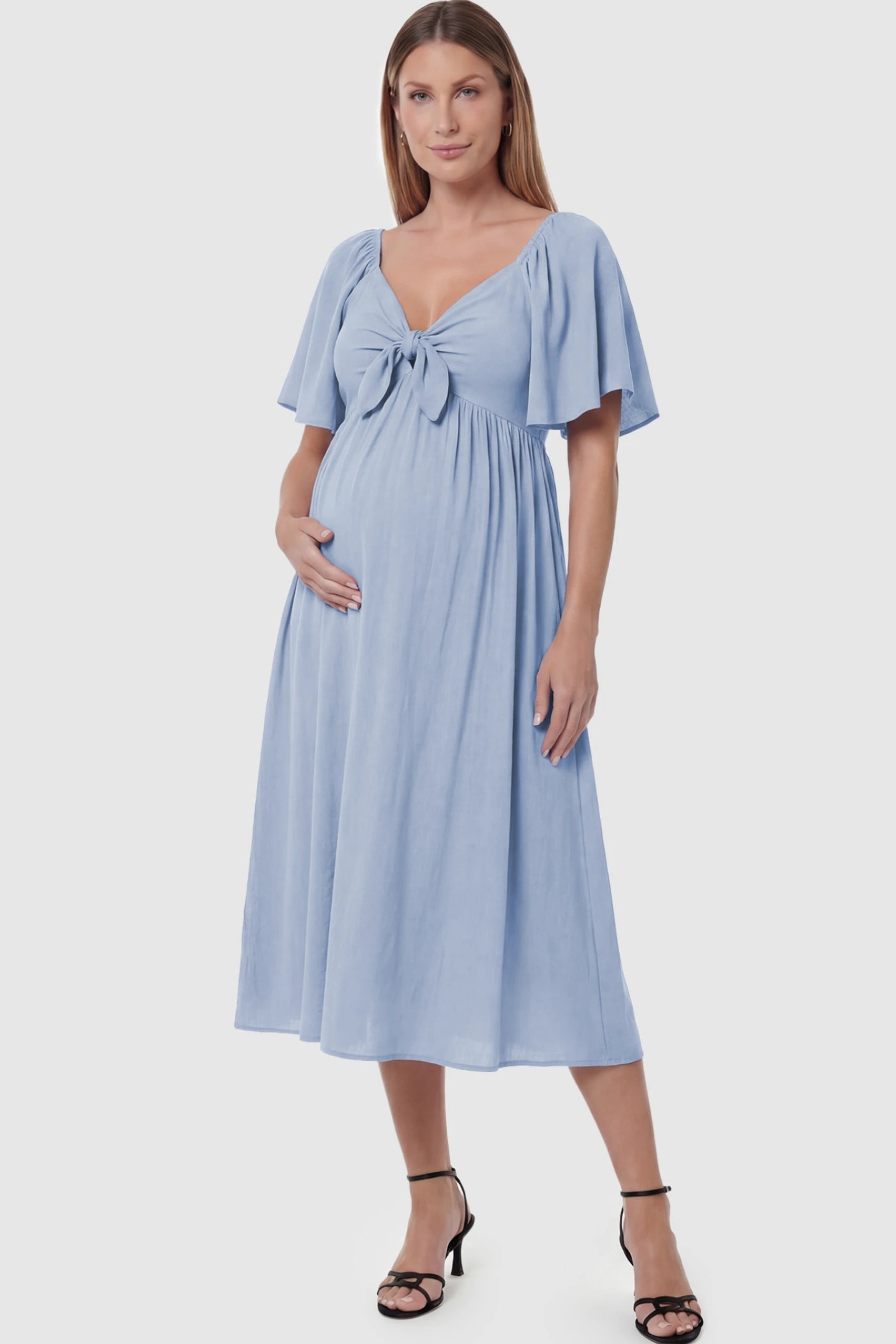 Front Tie Flutter Sleeve Maternity Midi Dress Front Tie Flutter Sleeve Maternity Midi Dress in light blue featuring a knotted V-neckline and flowy skirt on a pregnant model posing front.