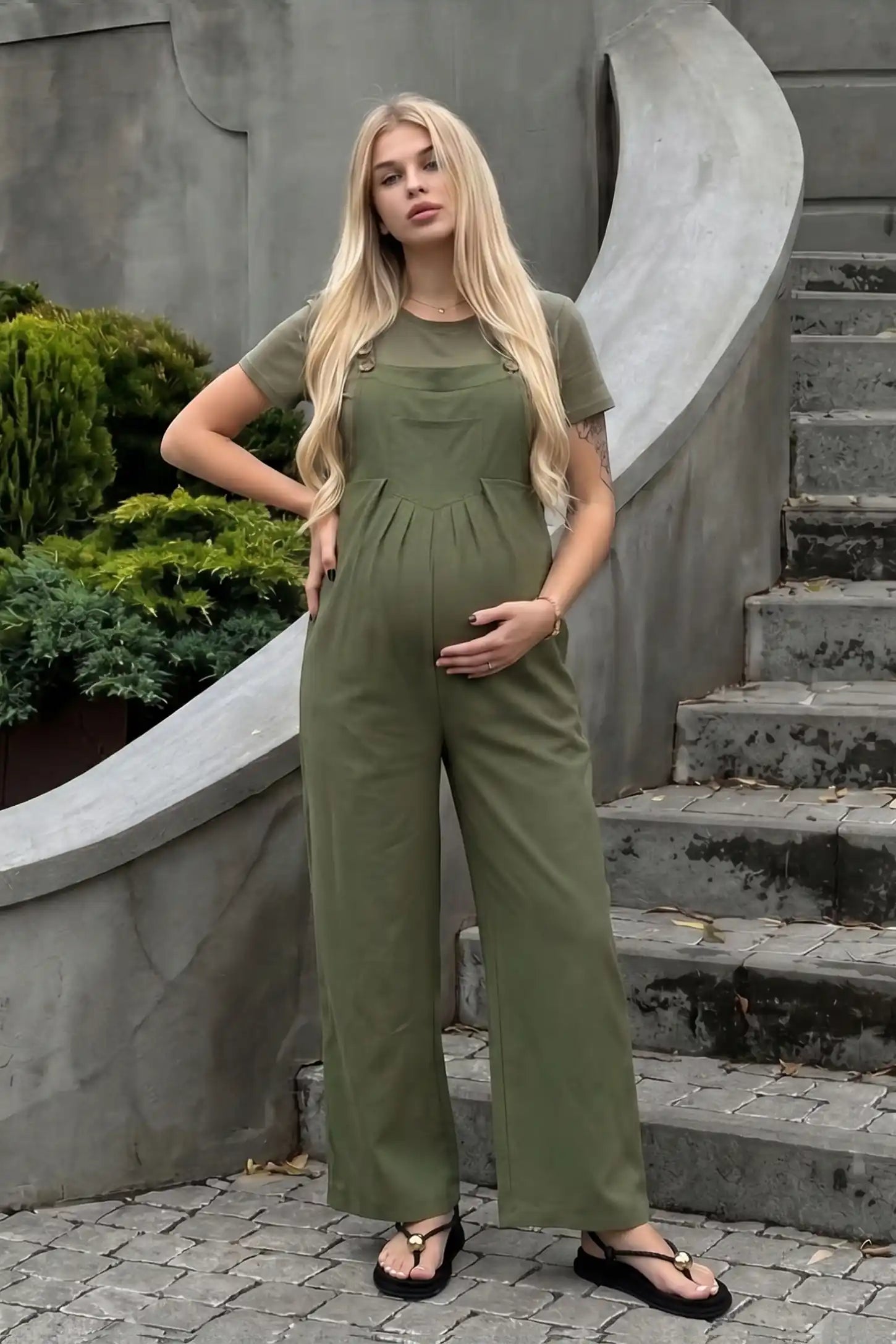 Full-Length Pocketed Maternity Jumpsuit Full-Length Pocketed Maternity Jumpsuit in Army Green featuring a relaxed wide-leg cut on a pregnant model, ugc view.