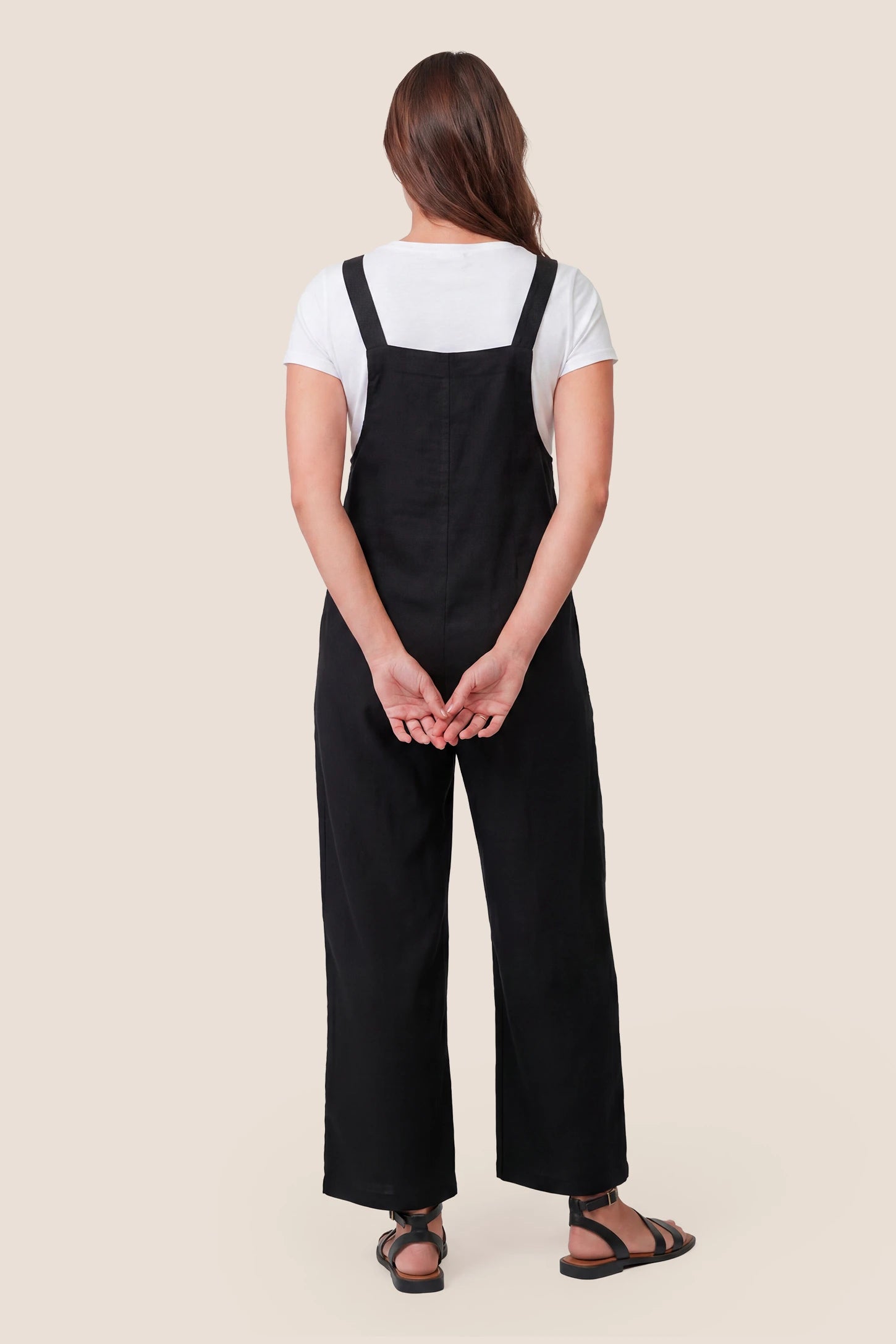 Full-Length Pocketed Maternity Jumpsuit Full-Length Pocketed Maternity Jumpsuit in Black featuring a relaxed wide-leg cut on a pregnant model, back view.
