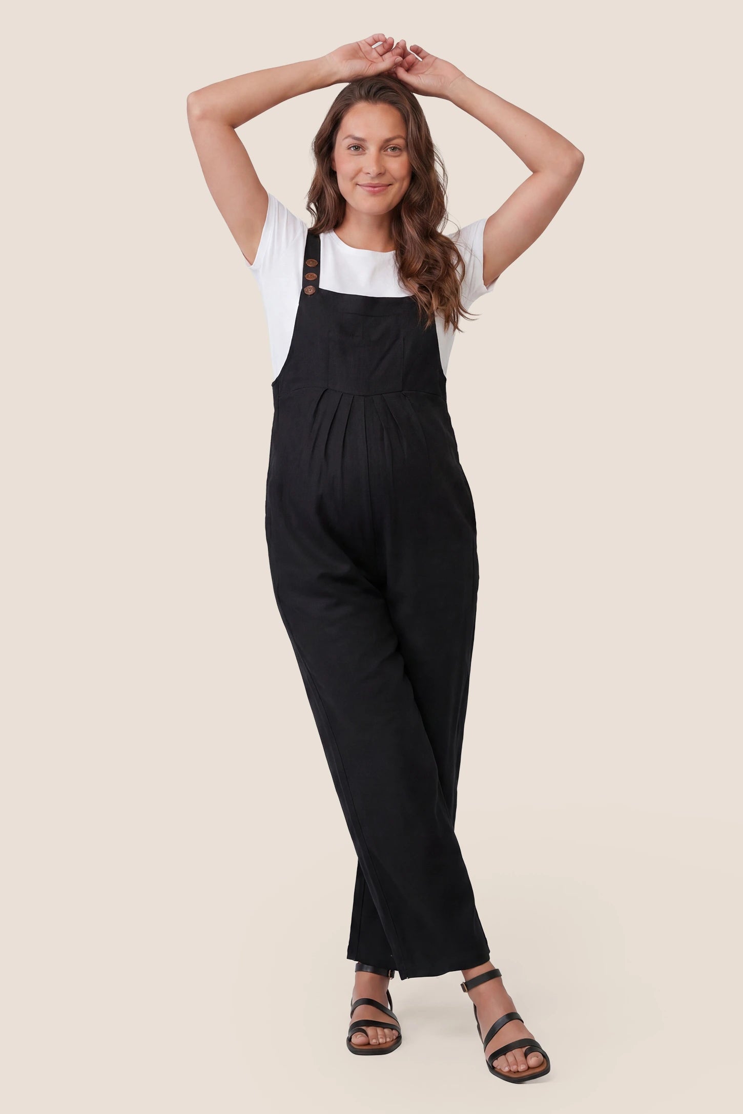 Full-Length Pocketed Maternity Jumpsuit Full-Length Pocketed Maternity Jumpsuit in Black featuring a relaxed wide-leg cut on a pregnant model, front view.
