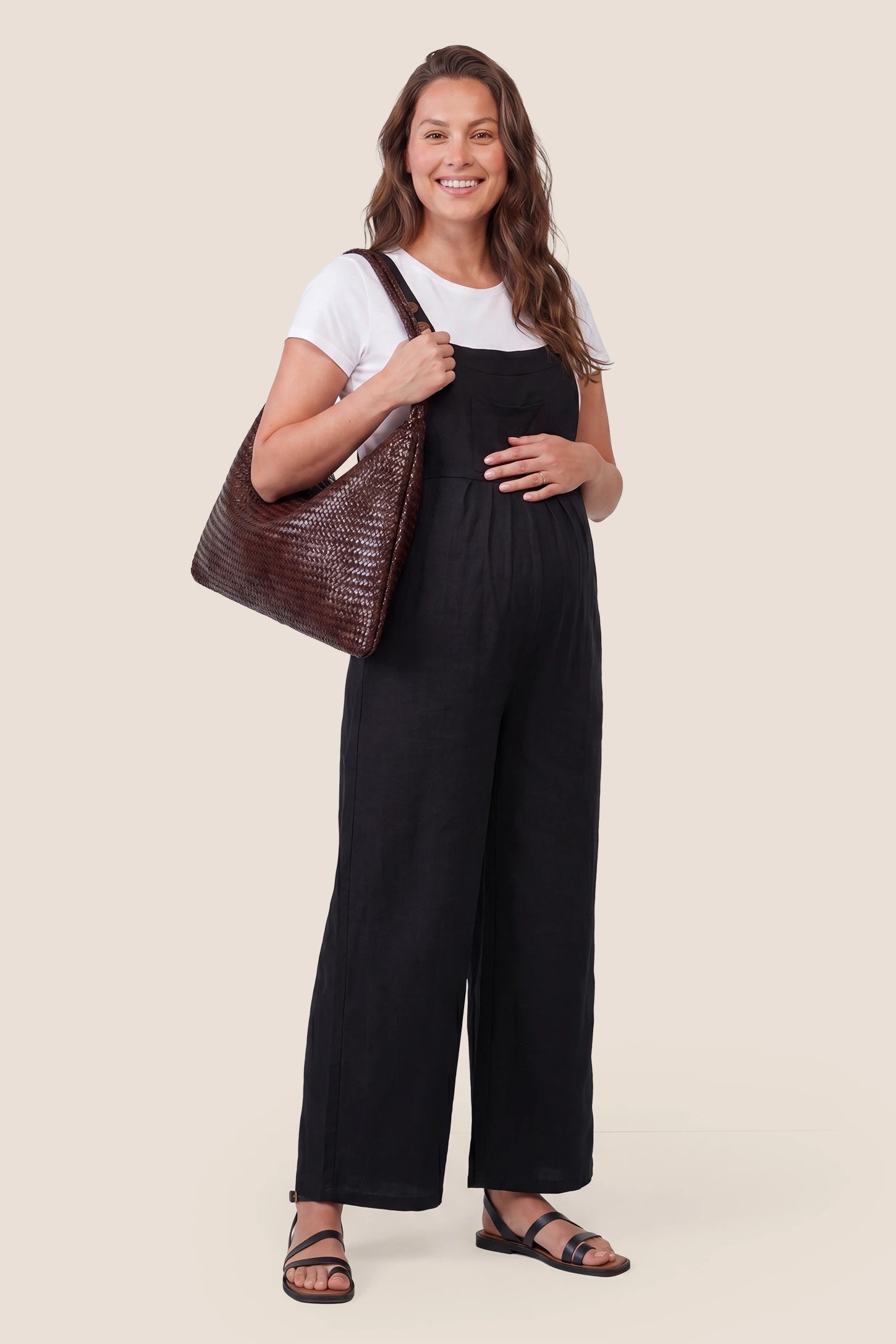 Full-Length Pocketed Maternity Jumpsuit in Black featuring a relaxed wide-leg cut on a pregnant model, styled lifestyle view.

