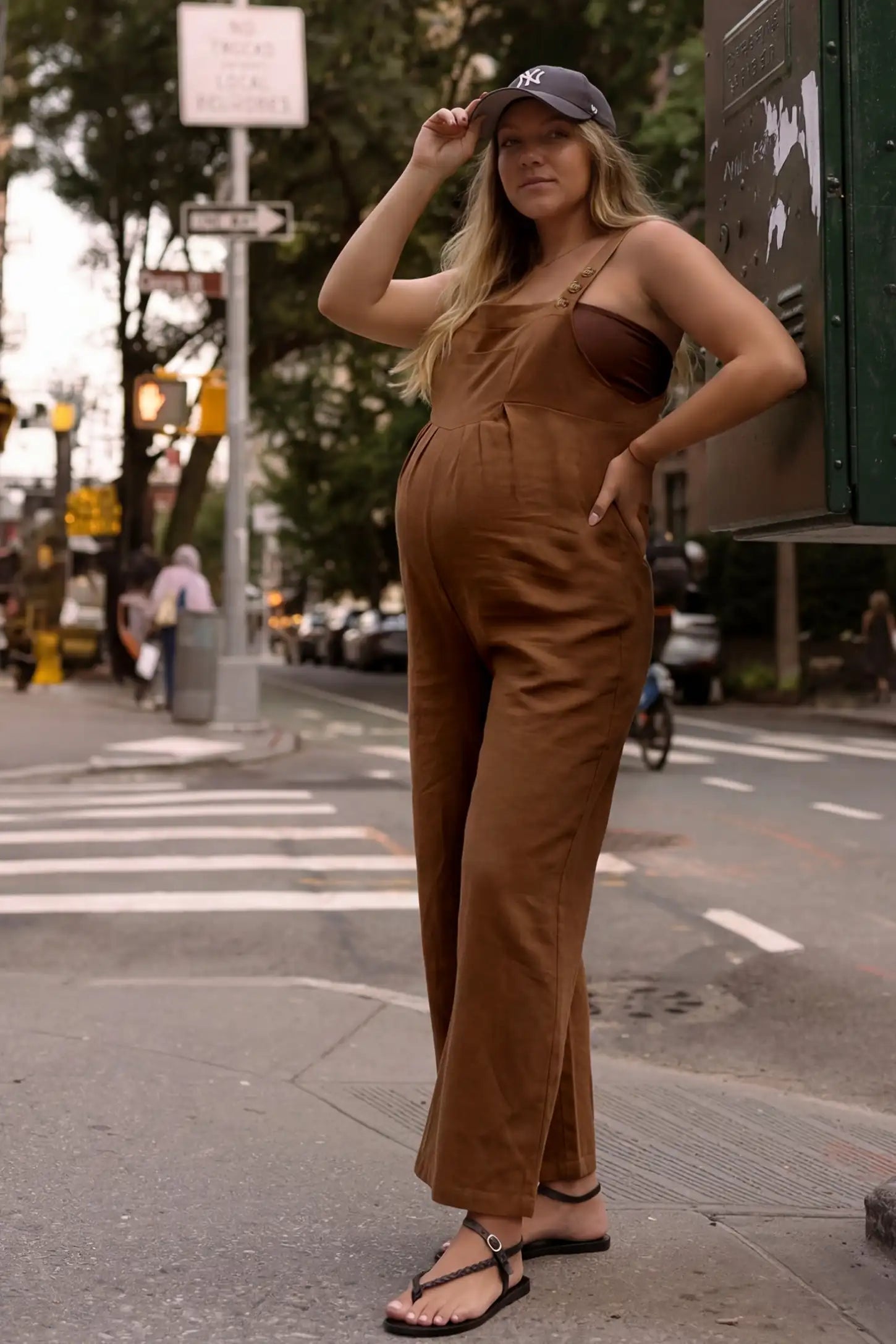 Full-Length Pocketed Maternity Jumpsuit Full-Length Pocketed Maternity Jumpsuit in Camel featuring a relaxed wide-leg cut on a pregnant model, editorial lifestyle view.
