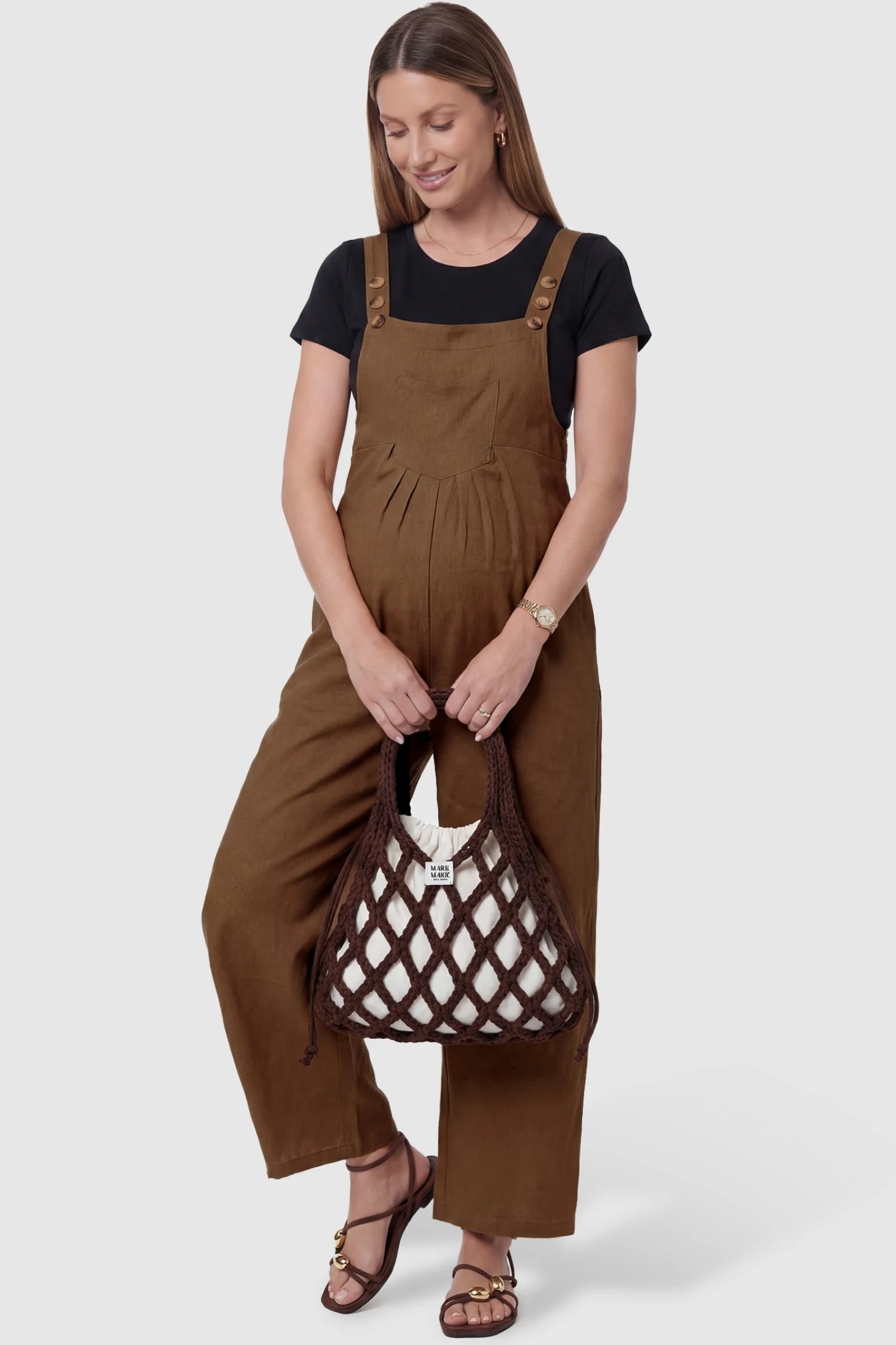 Full-Length Pocketed Maternity Jumpsuit Full-Length Pocketed Maternity Jumpsuit in Camel featuring a relaxed wide-leg cut on a pregnant model, stled lifestyle view.