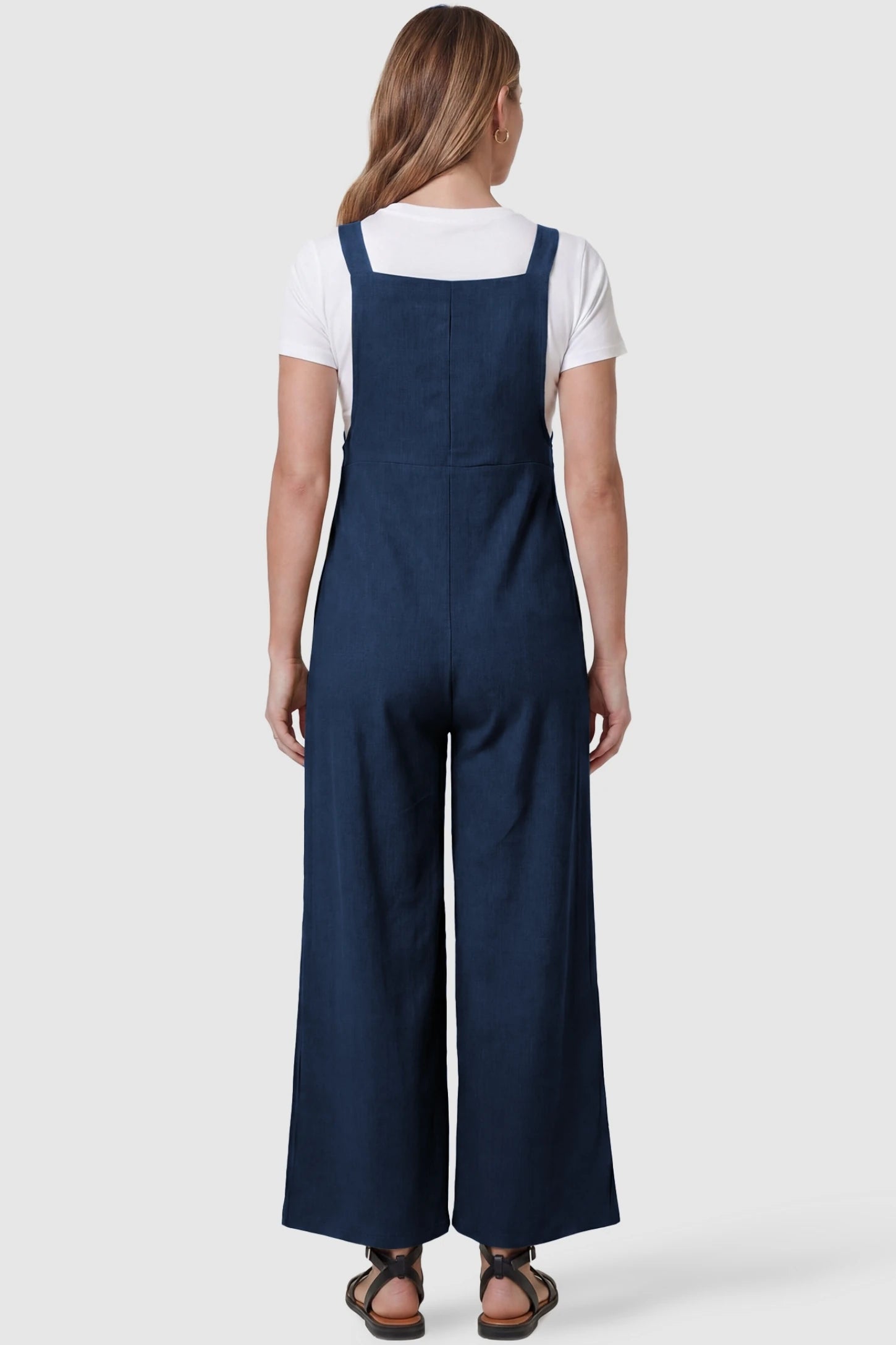 Full-Length Pocketed Maternity Jumpsuit Full-Length Pocketed Maternity Jumpsuit in Dark Blue featuring a relaxed wide-leg cut on a pregnant model, back view.
