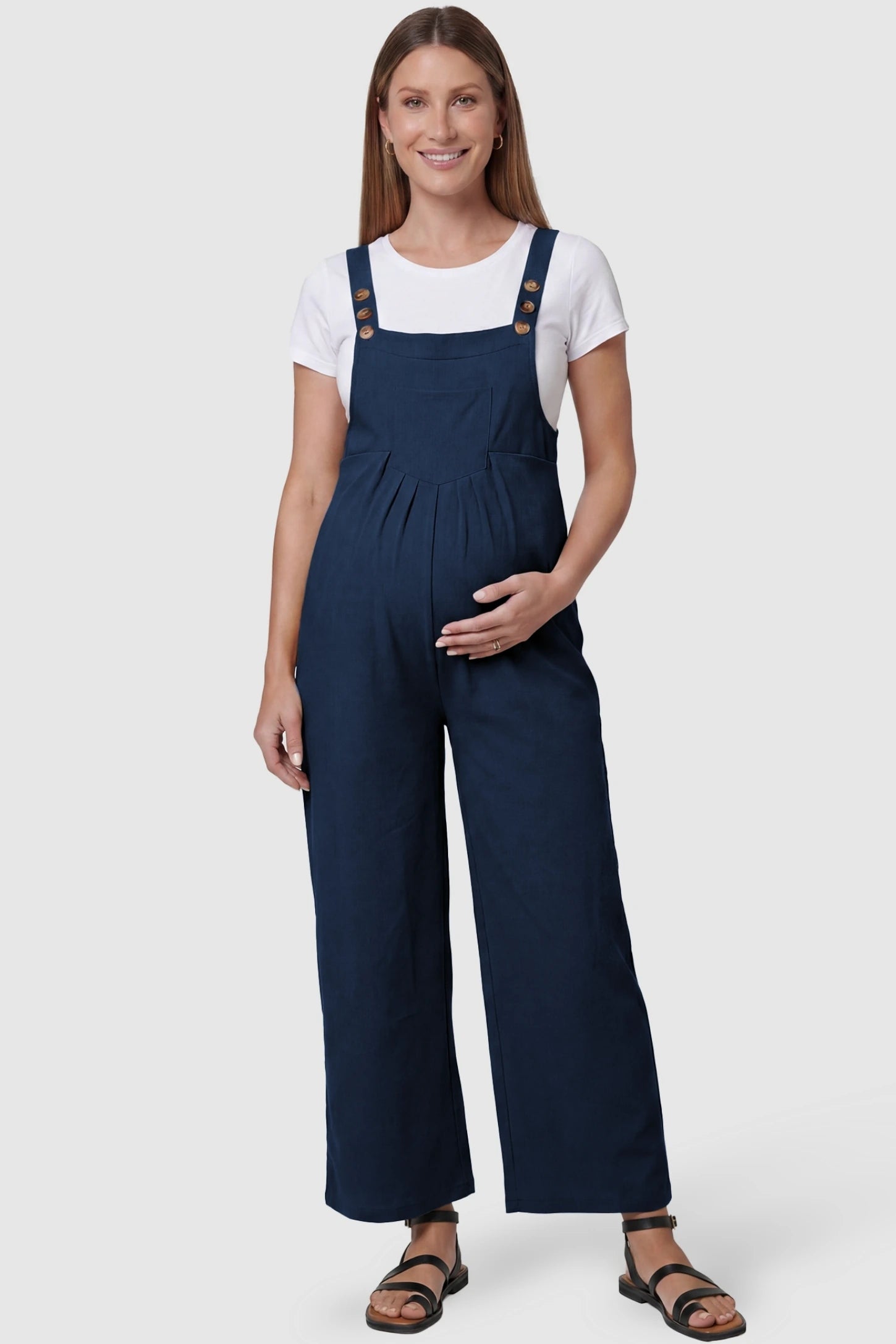 Full-Length Pocketed Maternity Jumpsuit Full-Length Pocketed Maternity Jumpsuit in Dark Blue featuring a relaxed wide-leg cut on a pregnant model, front view.