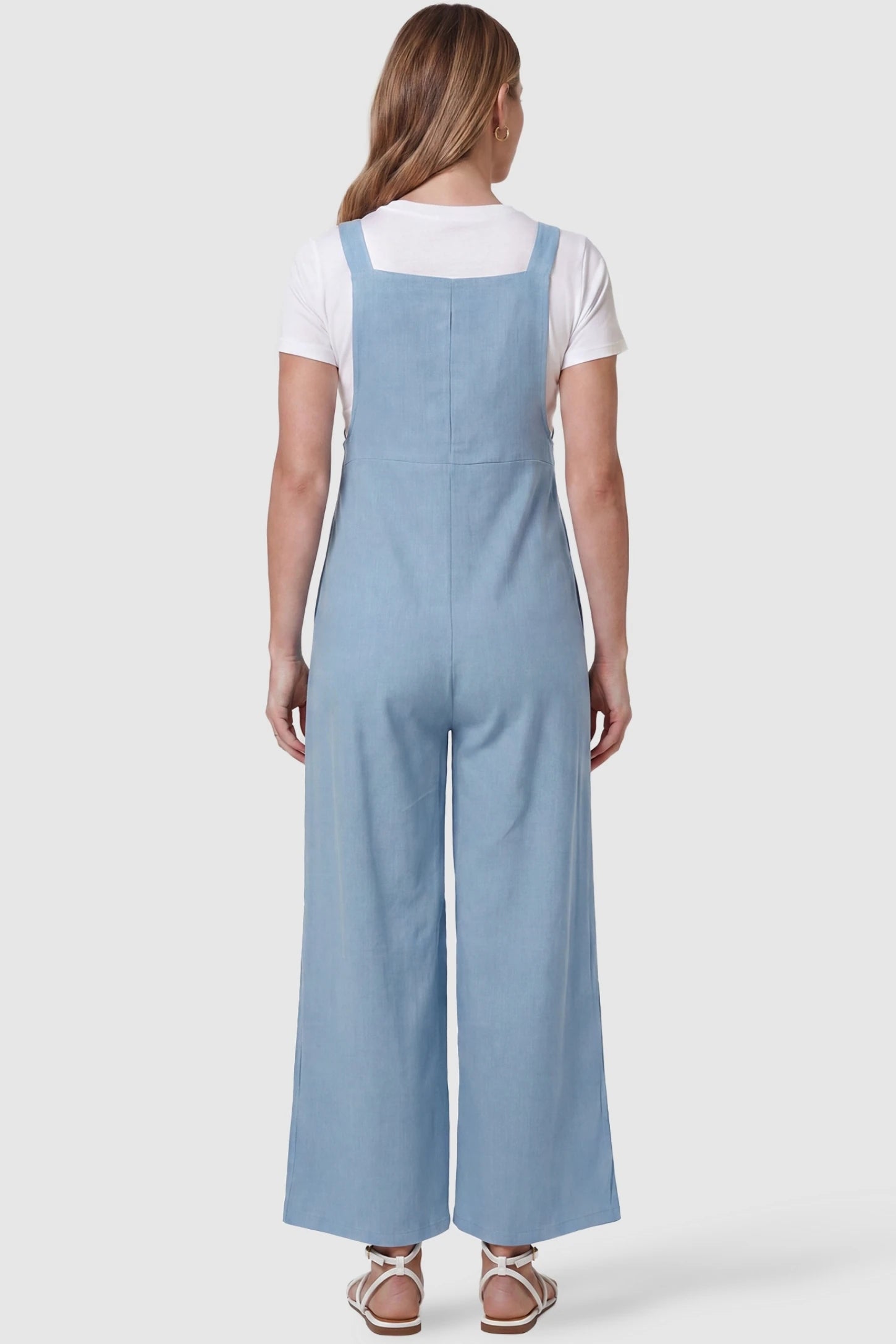 Full-Length Pocketed Maternity Jumpsuit Full-Length Pocketed Maternity Jumpsuit in Light Blue featuring a relaxed wide-leg cut on a pregnant model, back view.