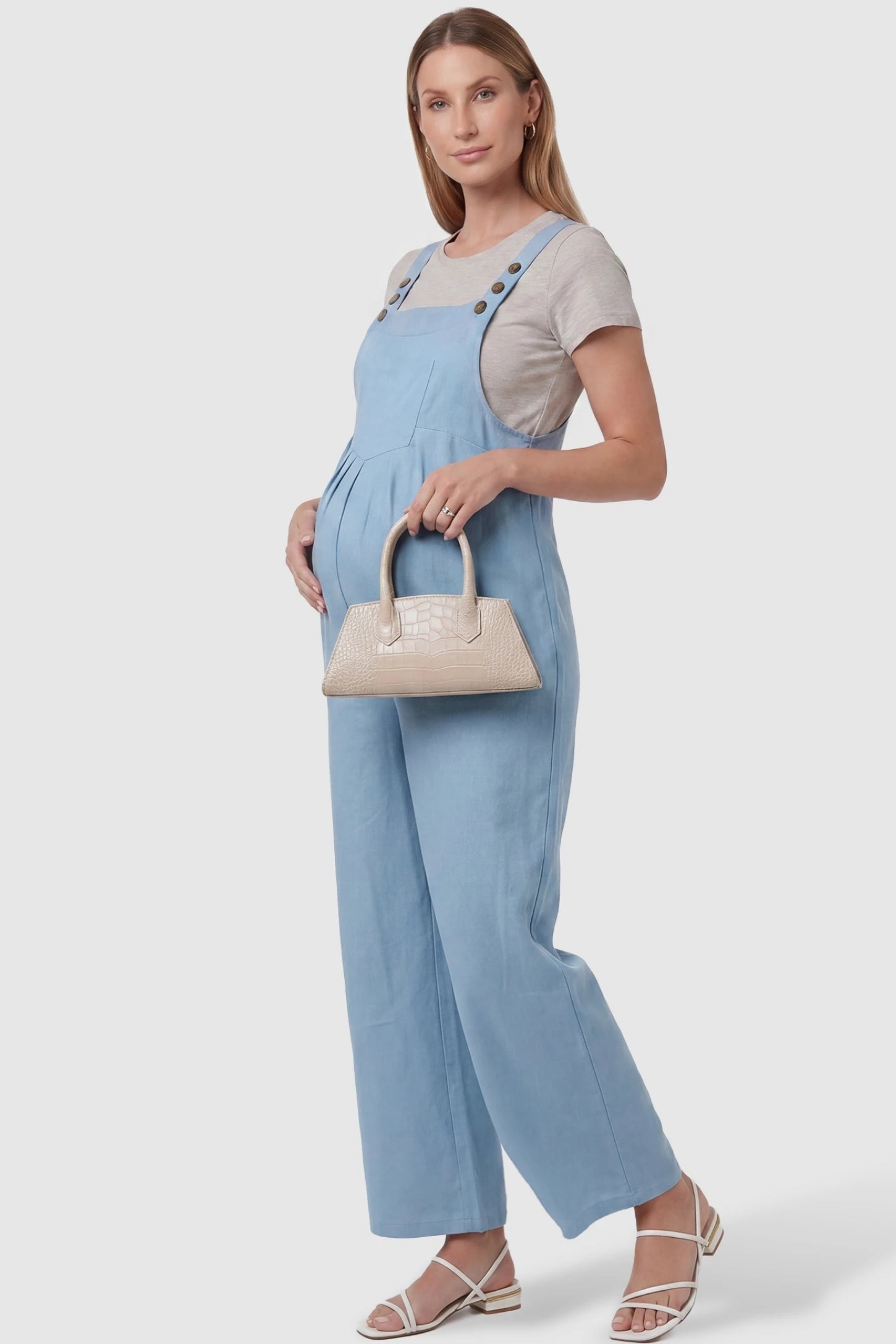 Full-Length Pocketed Maternity Jumpsuit Full-Length Pocketed Maternity Jumpsuit in Light Blue featuring a relaxed wide-leg cut on a pregnant model, styled lifestyle view.
