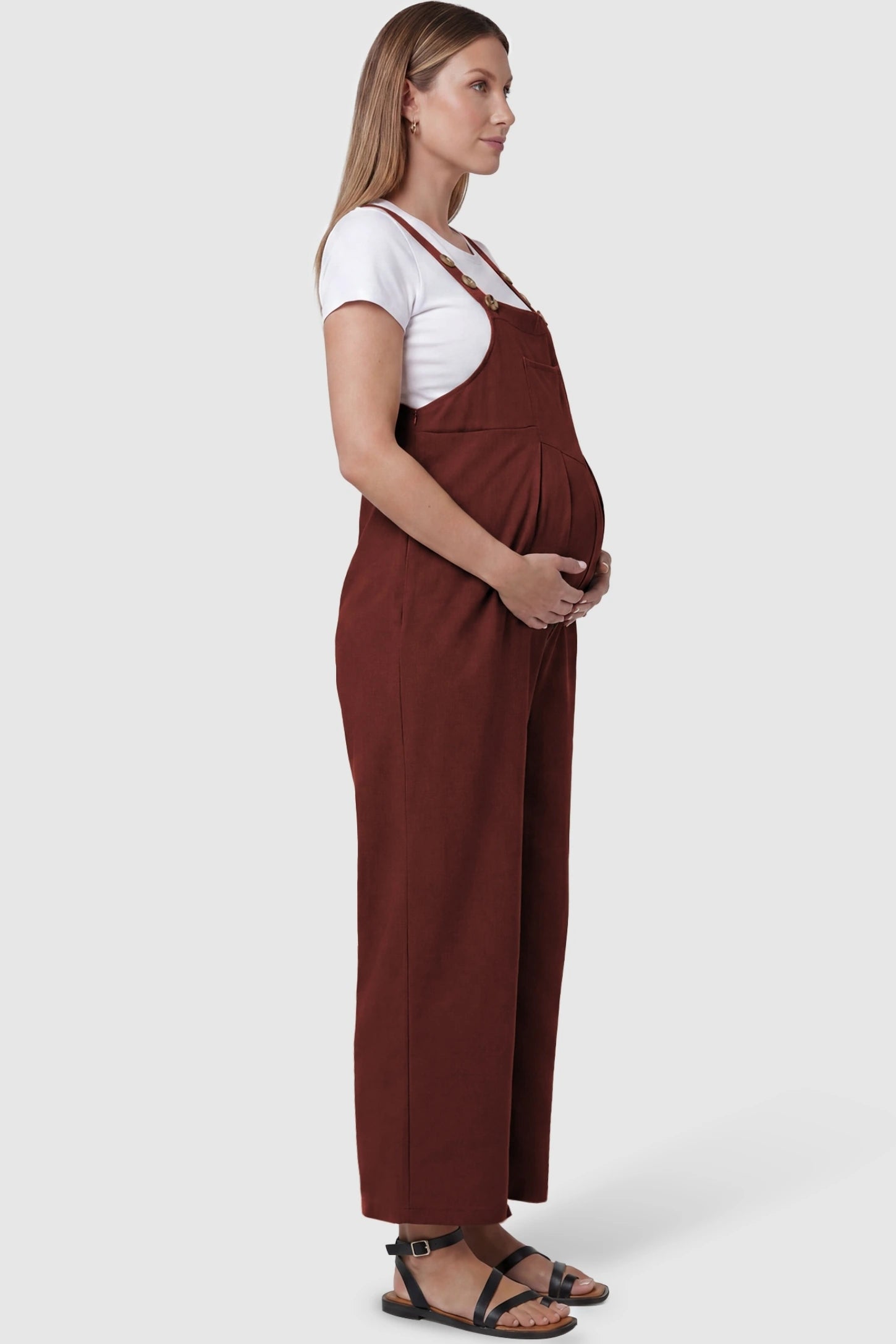 Full-Length Pocketed Maternity Jumpsuit Full-Length Pocketed Maternity Jumpsuit in Orange Red featuring a relaxed wide-leg cut on a pregnant model, side view.