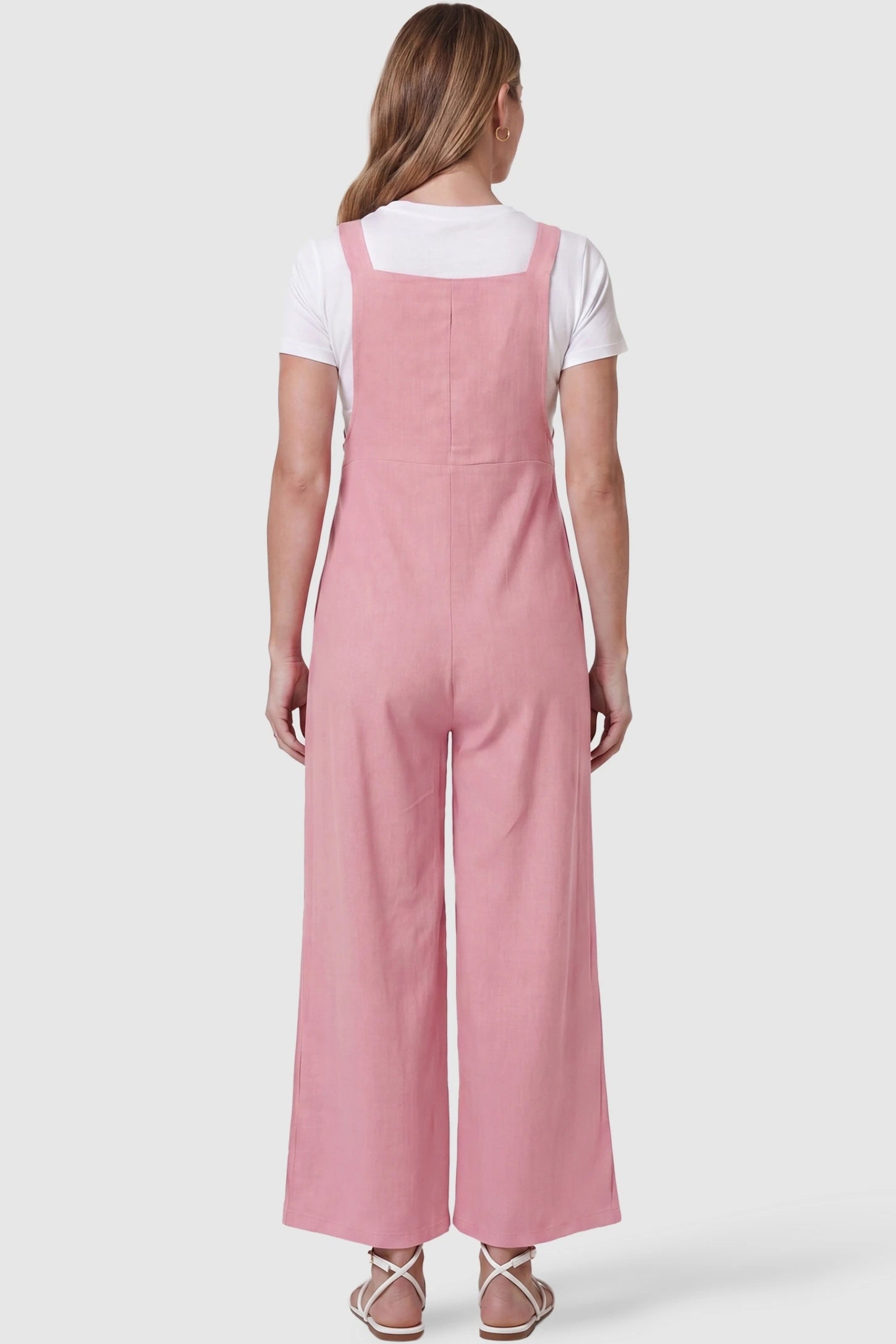 Full-Length Pocketed Maternity Jumpsuit Full-Length Pocketed Maternity Jumpsuit in Pink featuring a relaxed wide-leg cut on a pregnant model, back view.