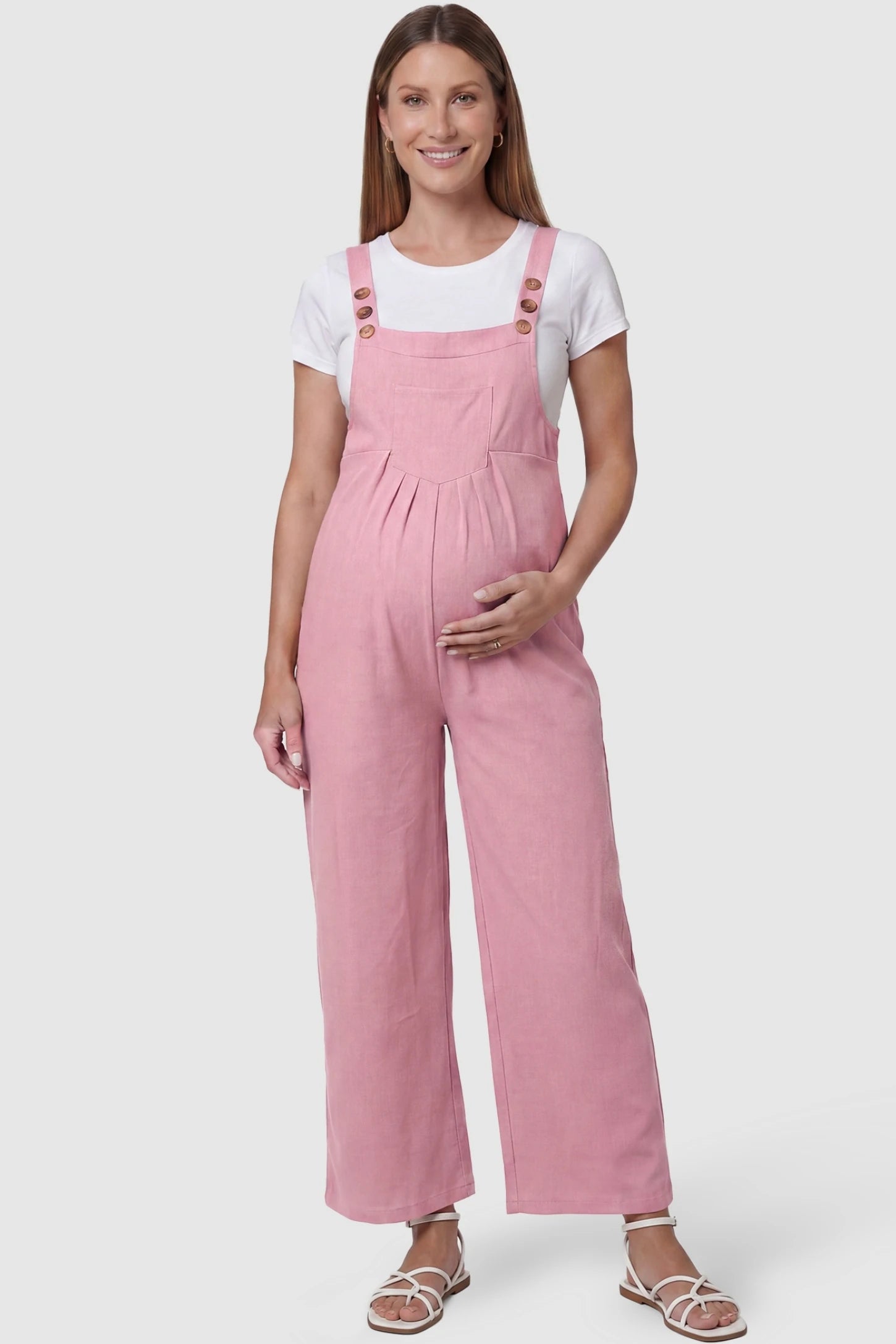 Full-Length Pocketed Maternity Jumpsuit Full-Length Pocketed Maternity Jumpsuit in Pink featuring a relaxed wide-leg cut on a pregnant model, front view.