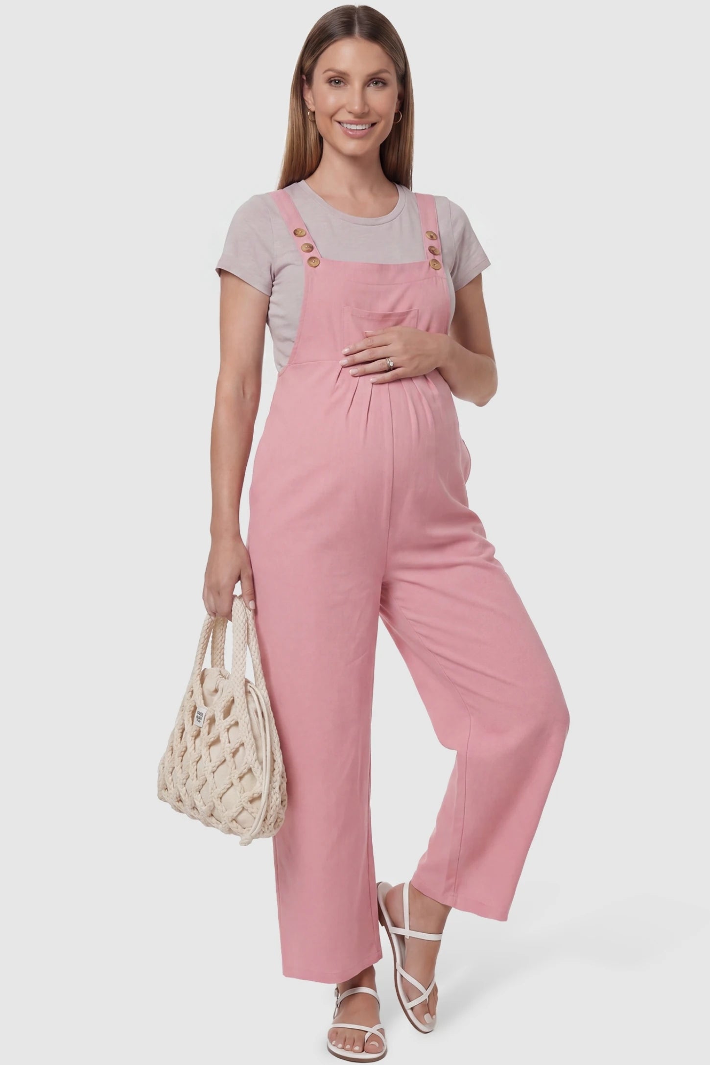 Full-Length Pocketed Maternity Jumpsuit Full-Length Pocketed Maternity Jumpsuit in Pink featuring a relaxed wide-leg cut on a pregnant model, styled lifestyle view.