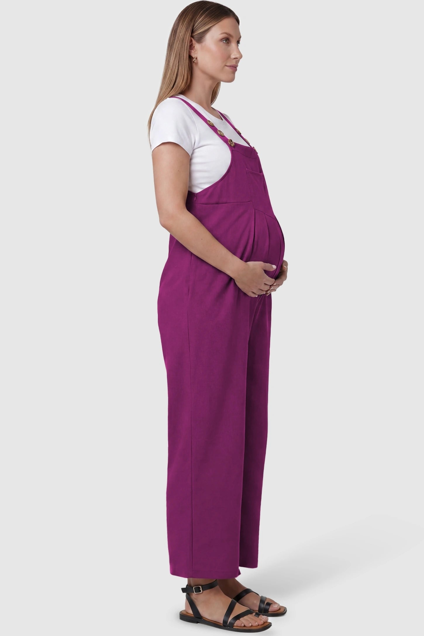 Full-Length Pocketed Maternity Jumpsuit Full-Length Pocketed Maternity Jumpsuit in Wine Red featuring a relaxed wide-leg cut on a pregnant model, side view.