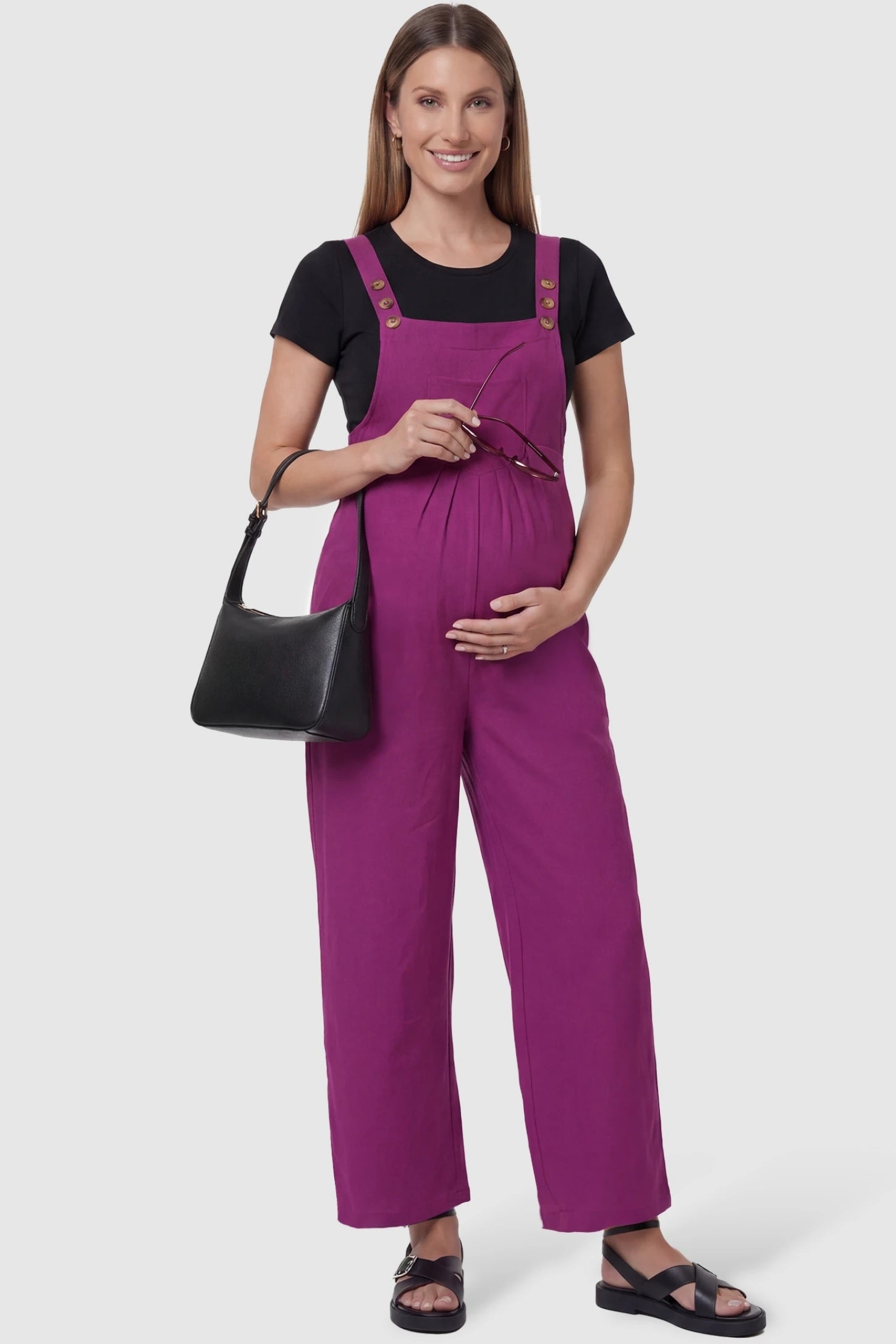 Full-Length Pocketed Maternity Jumpsuit Full-Length Pocketed Maternity Jumpsuit in Wine Red featuring a relaxed wide-leg cut on a pregnant model, styled lifestyle view.