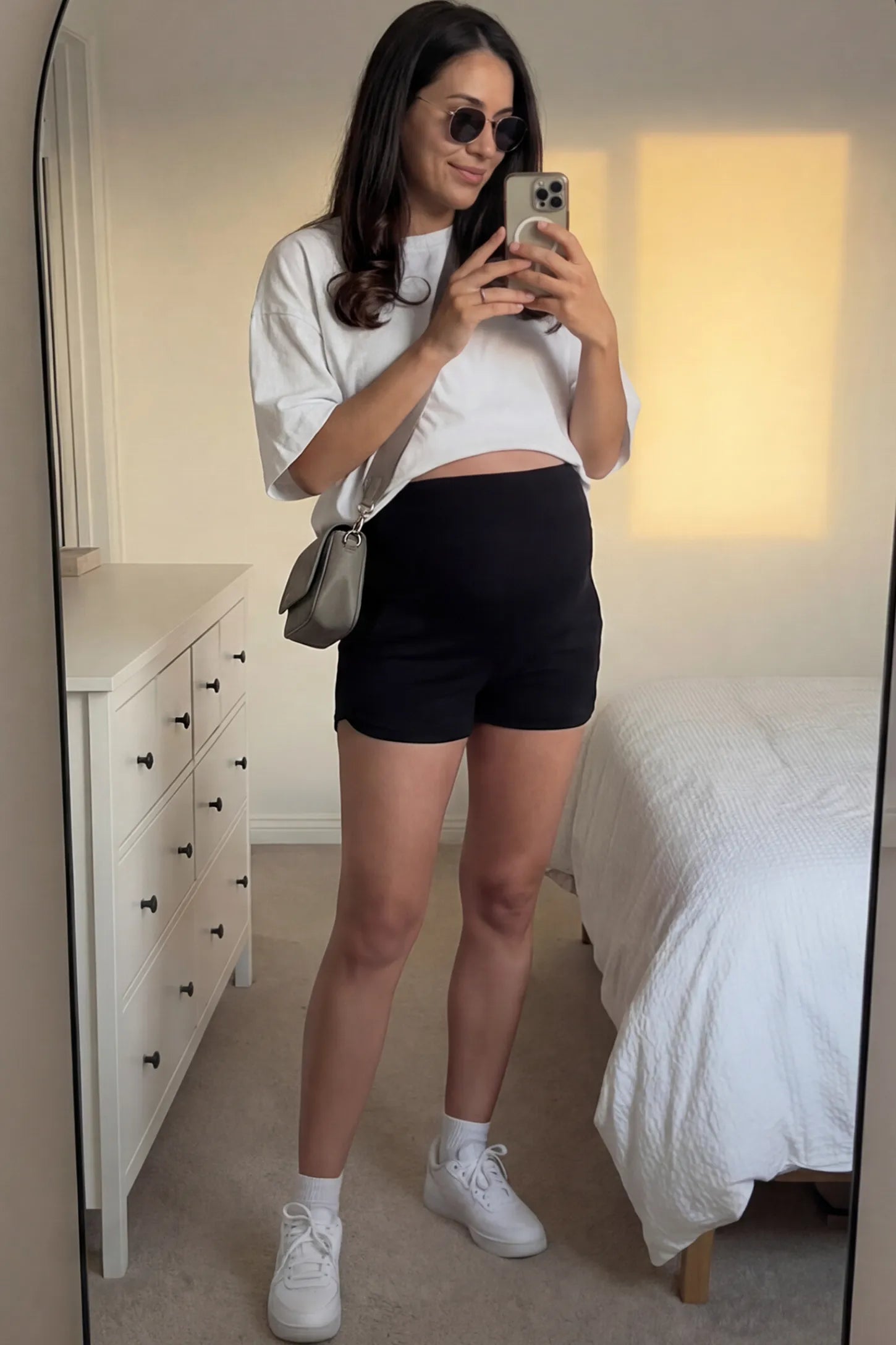 Full Panel Dolphin Hem Maternity Lounge Shorts Full Panel Maternity Lounge Shorts in Black featuring a dolphin hem on a pregnant woman.