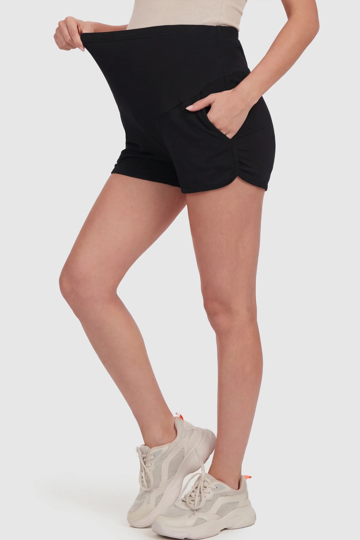 Full Panel Dolphin Hem Maternity Lounge Shorts Full Panel Maternity Lounge Shorts in Black featuring a dolphin hem on a pregnant model showing side.