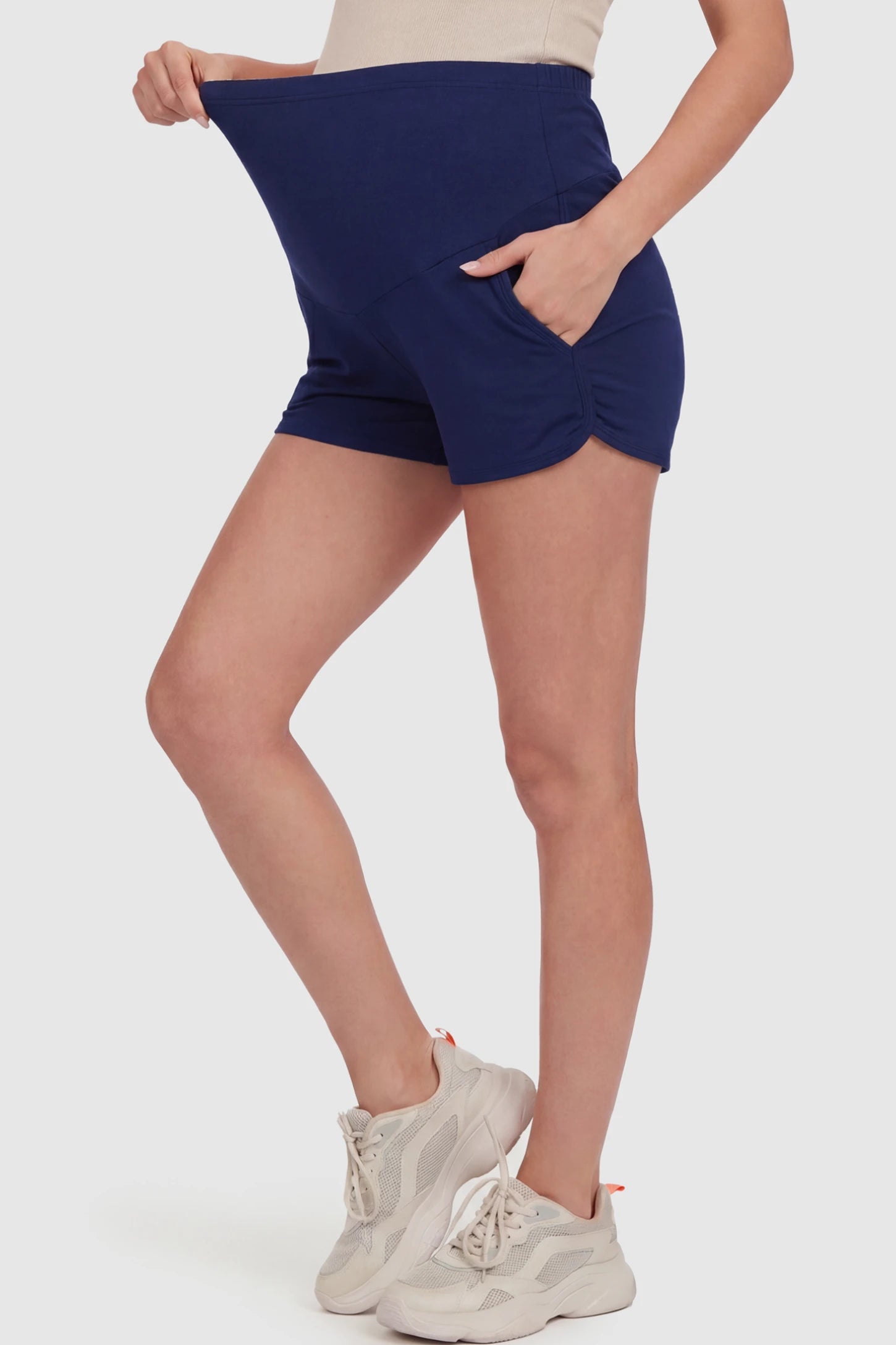 Full Panel Dolphin Hem Maternity Lounge Shorts Full Panel Maternity Lounge Shorts in Blue featuring a dolphin hem on a pregnant model showing side.