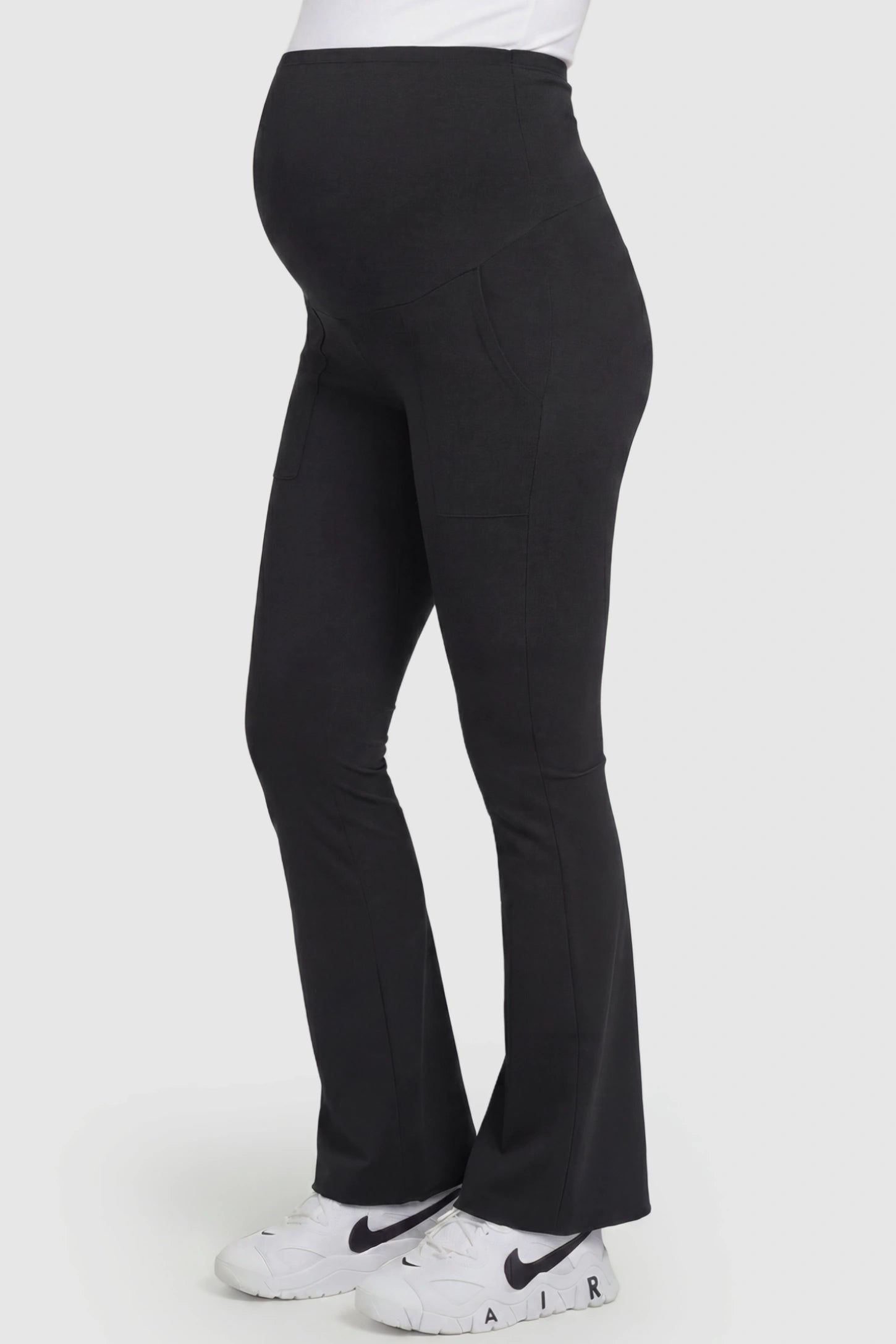 Full Panel Pocketed Flare Leg Maternity Leggings Full Panel Pocketed Flare Leg Maternity Leggings in Black featuring a ribbed over-the-bump panel on a pregnant model, side view.