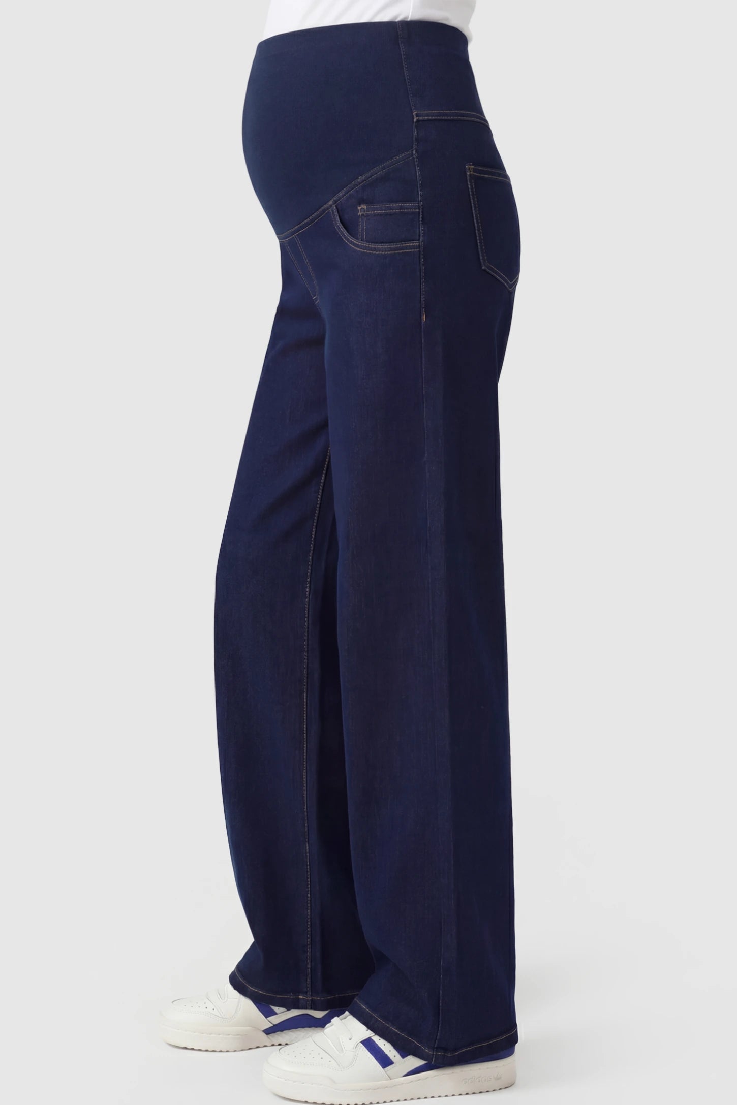 Full Panel Relaxed Wide Leg Maternity Jeans Full Panel Wide-Leg Maternity Jeans in Blue featuring a belly panel on a pregnant model showing side.